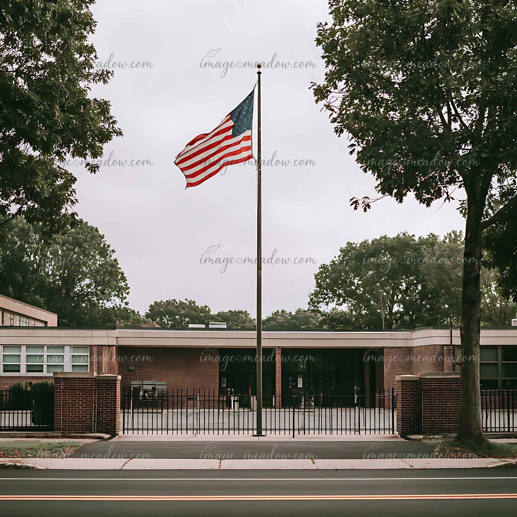 A flag is waving outside a school building.
