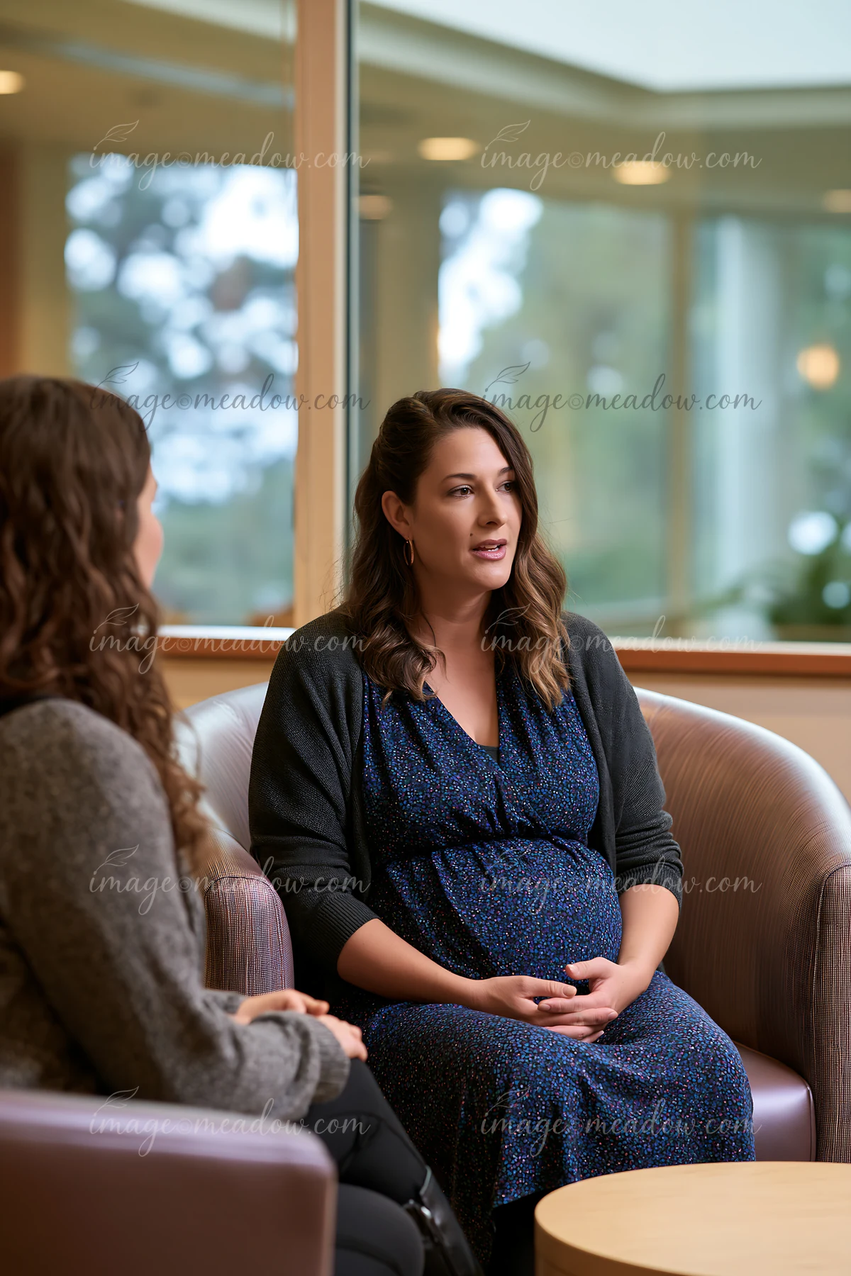 A therapist listens to a bereaved person in a cozy room with natural light.