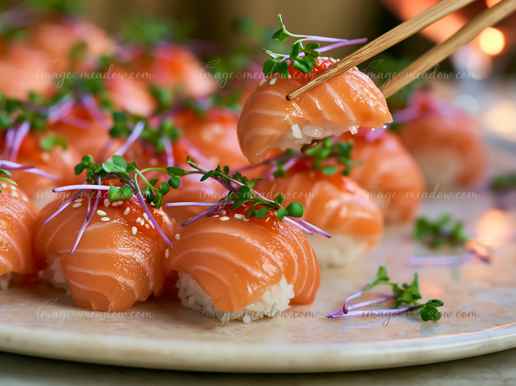 Sushi with microgreens close-up showcases pieces of salmon sushi garnished with microgreens held by chopsticks.
