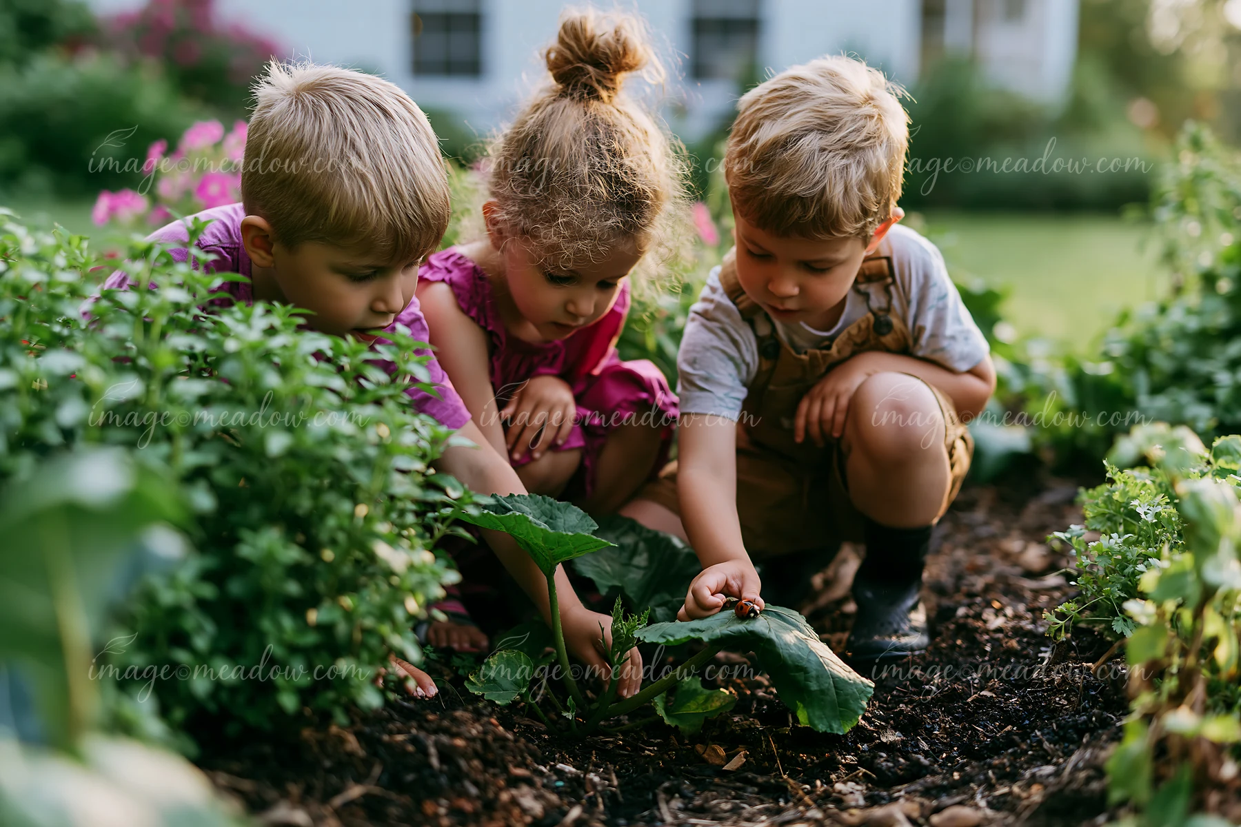 Three children play together while gardening in a farmhouse garden.