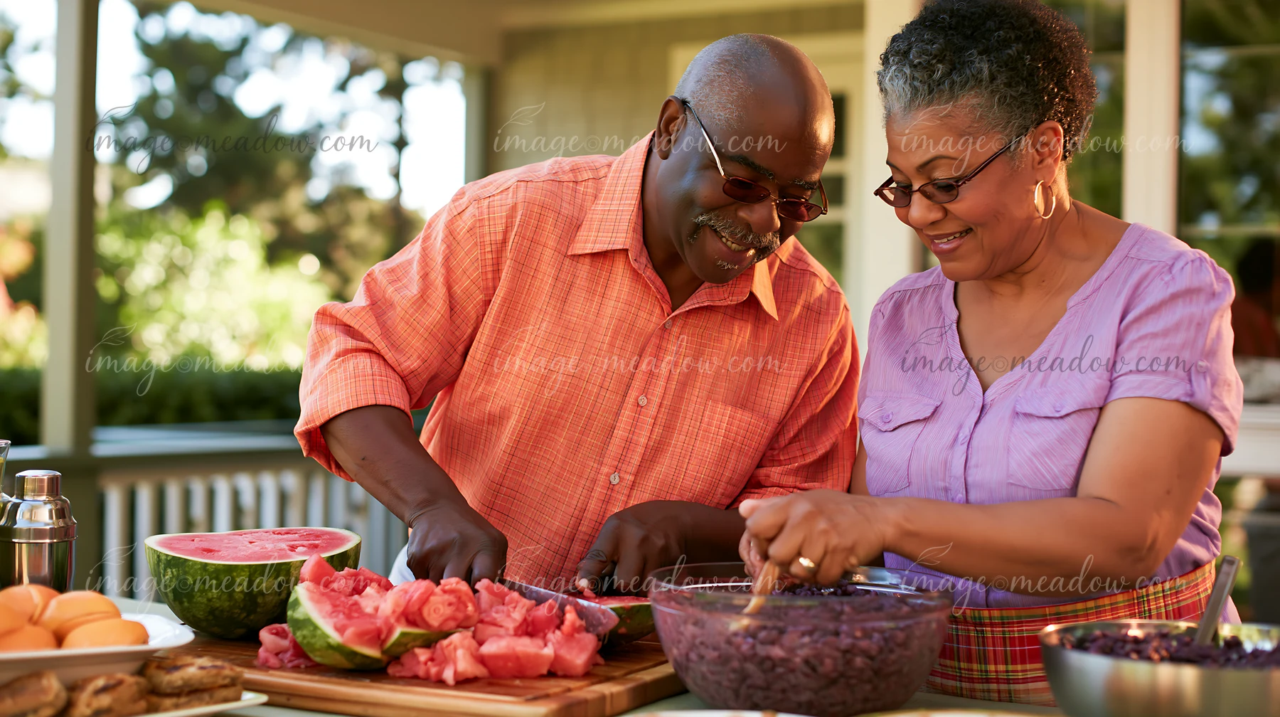 Two senior spouses are preparing a family meal together in a garden.