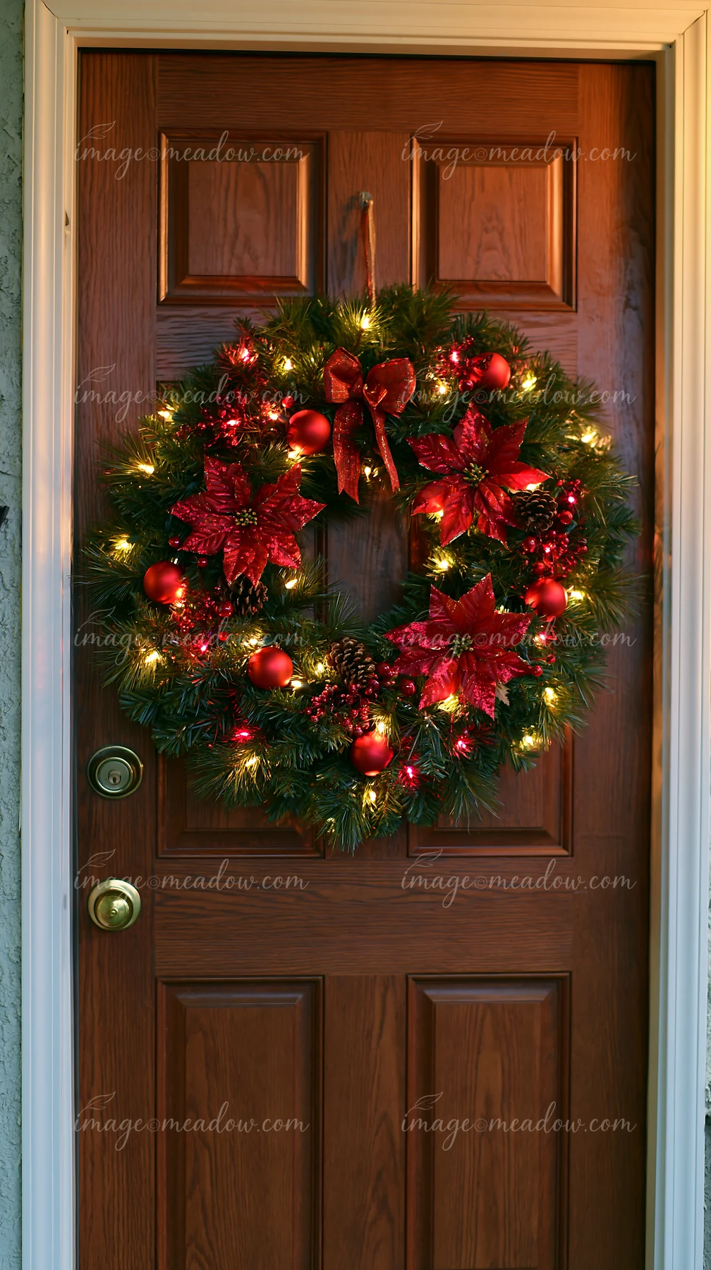A Christmas wreath hangs on an apartment door.