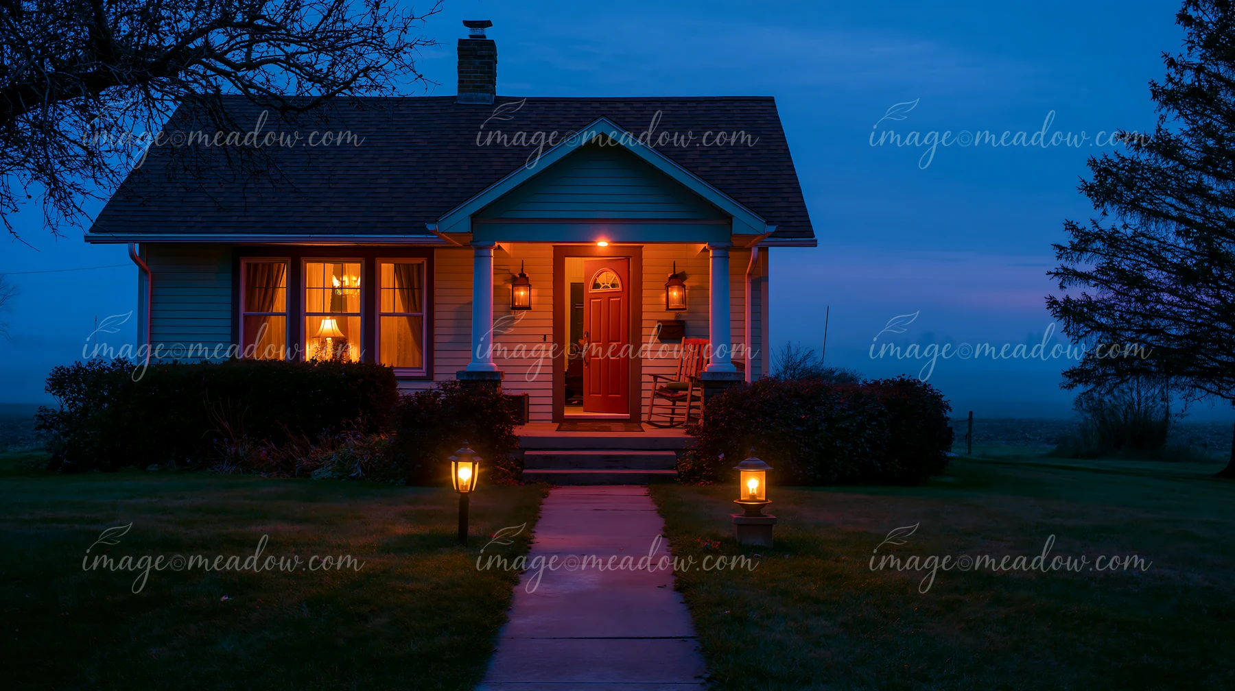 A country house with open front door is lit by warm light during dusk.