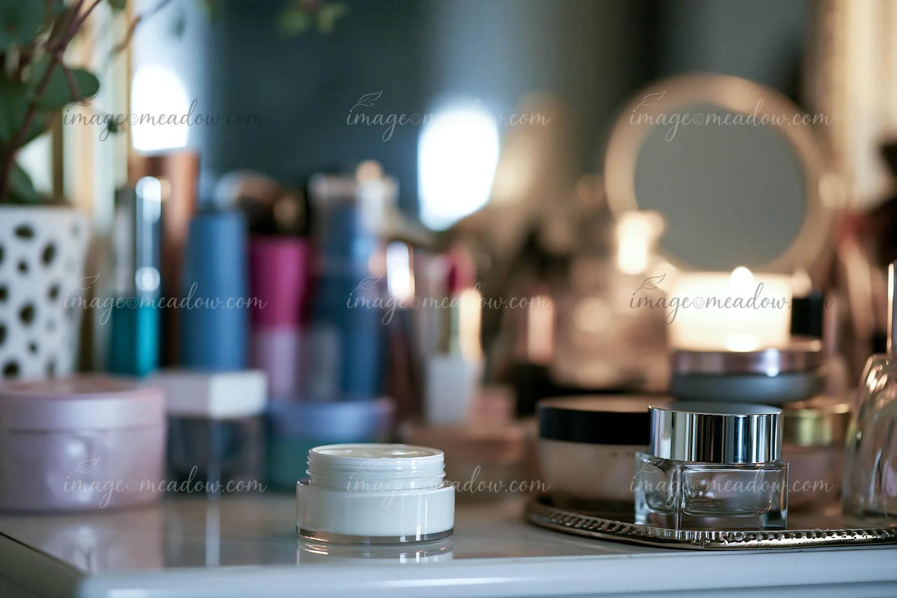 A cream dose sits on a white dresser surrounded by various unbranded cosmetic containers.