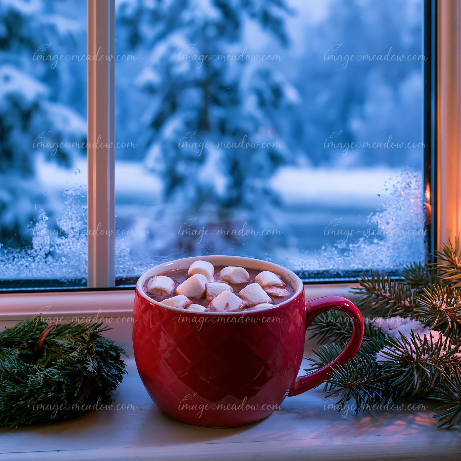 A large red mug holds warm cocoa topped with marshmallows, placed on a windowsill.