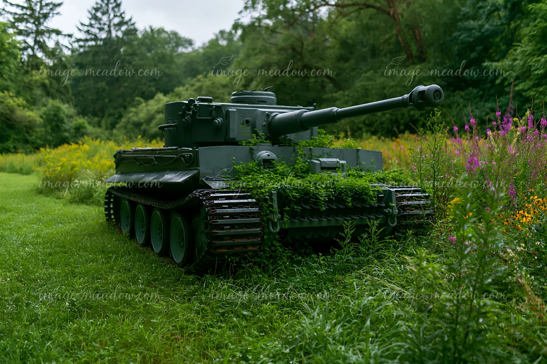 A military tank sits partially covered in grass and plants within a vibrant landscape.