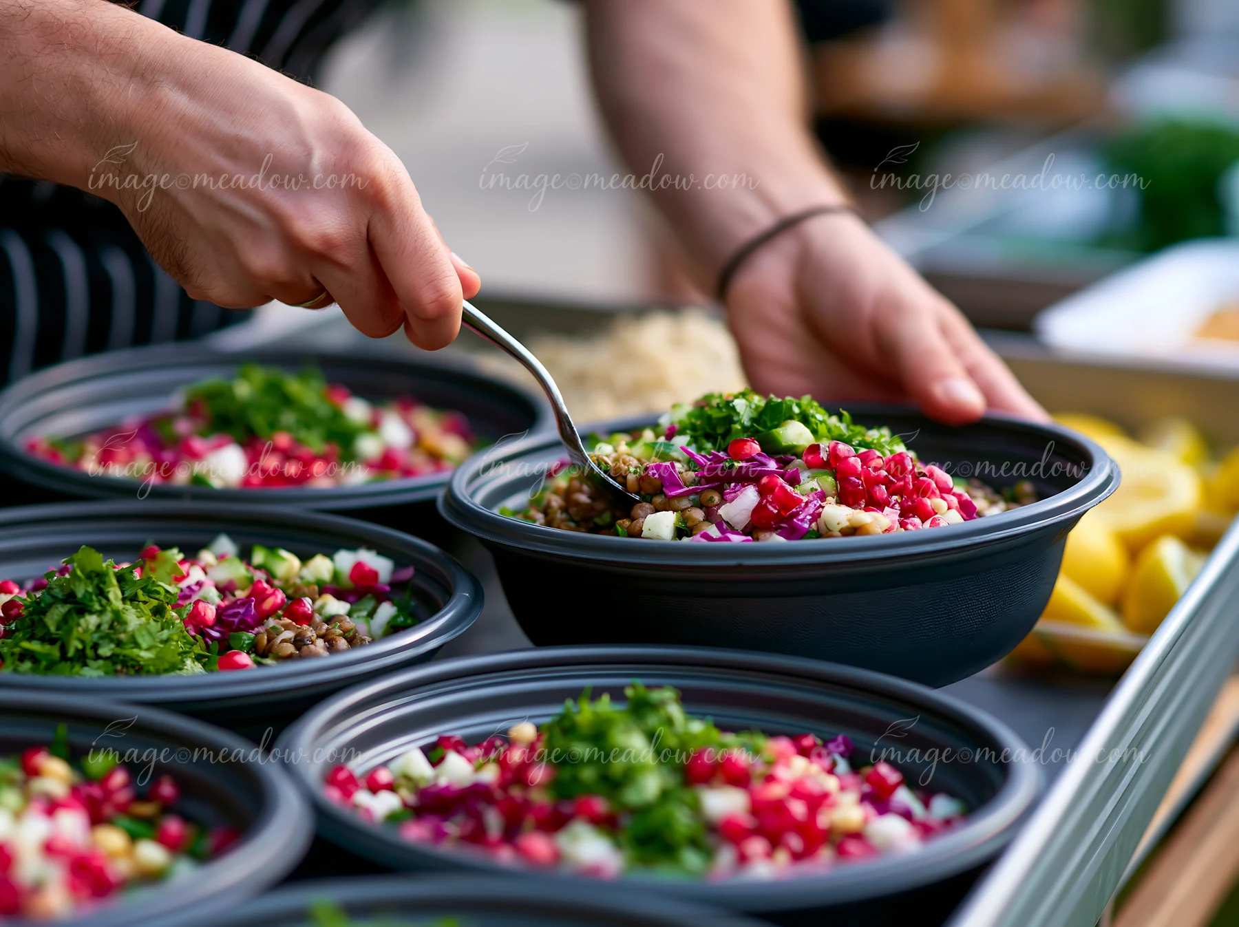 A person is serving fresh salads at a sustainable buffet catering event.