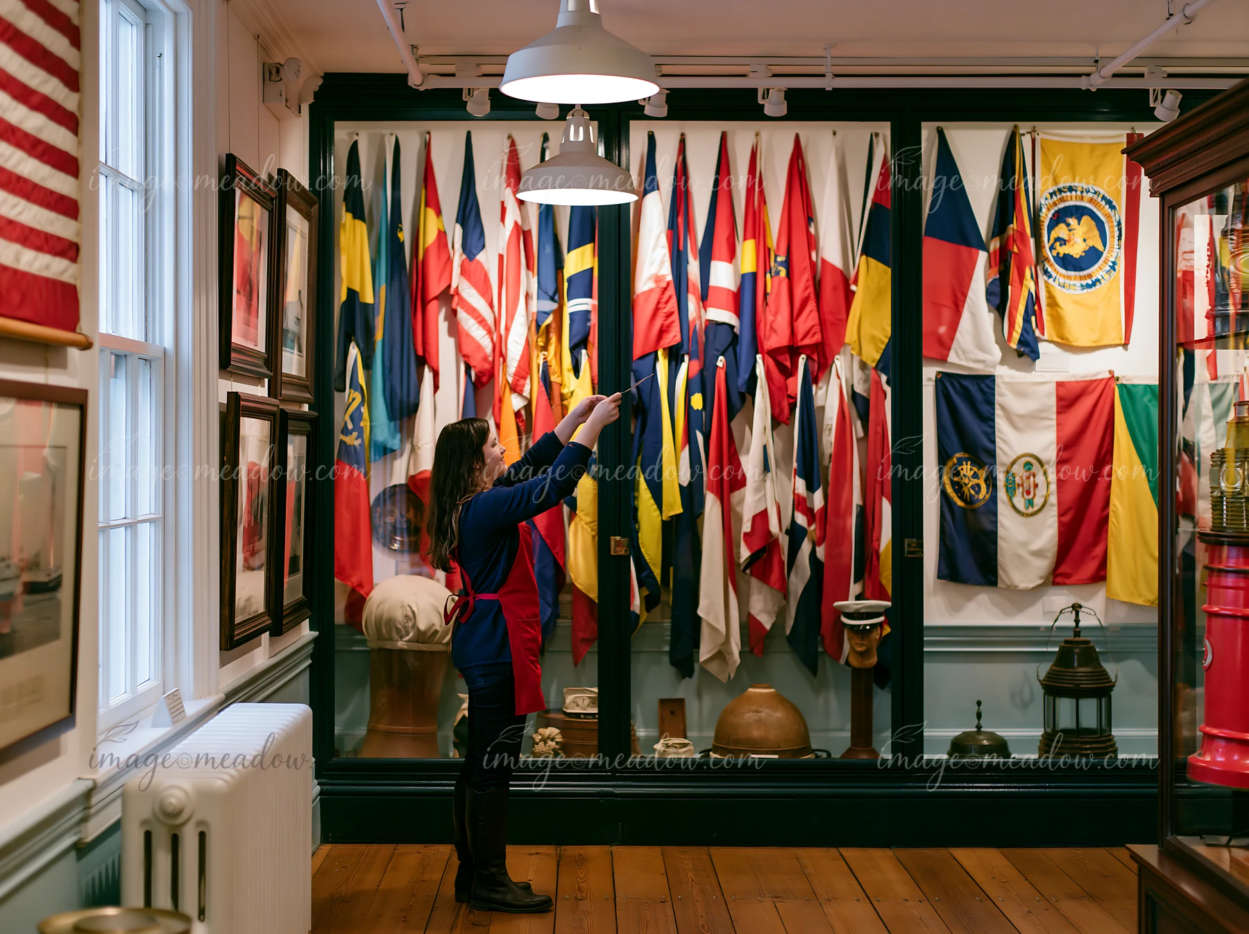 A visitor inspects maritime flags displayed on walls in the lighthouse museum interior.