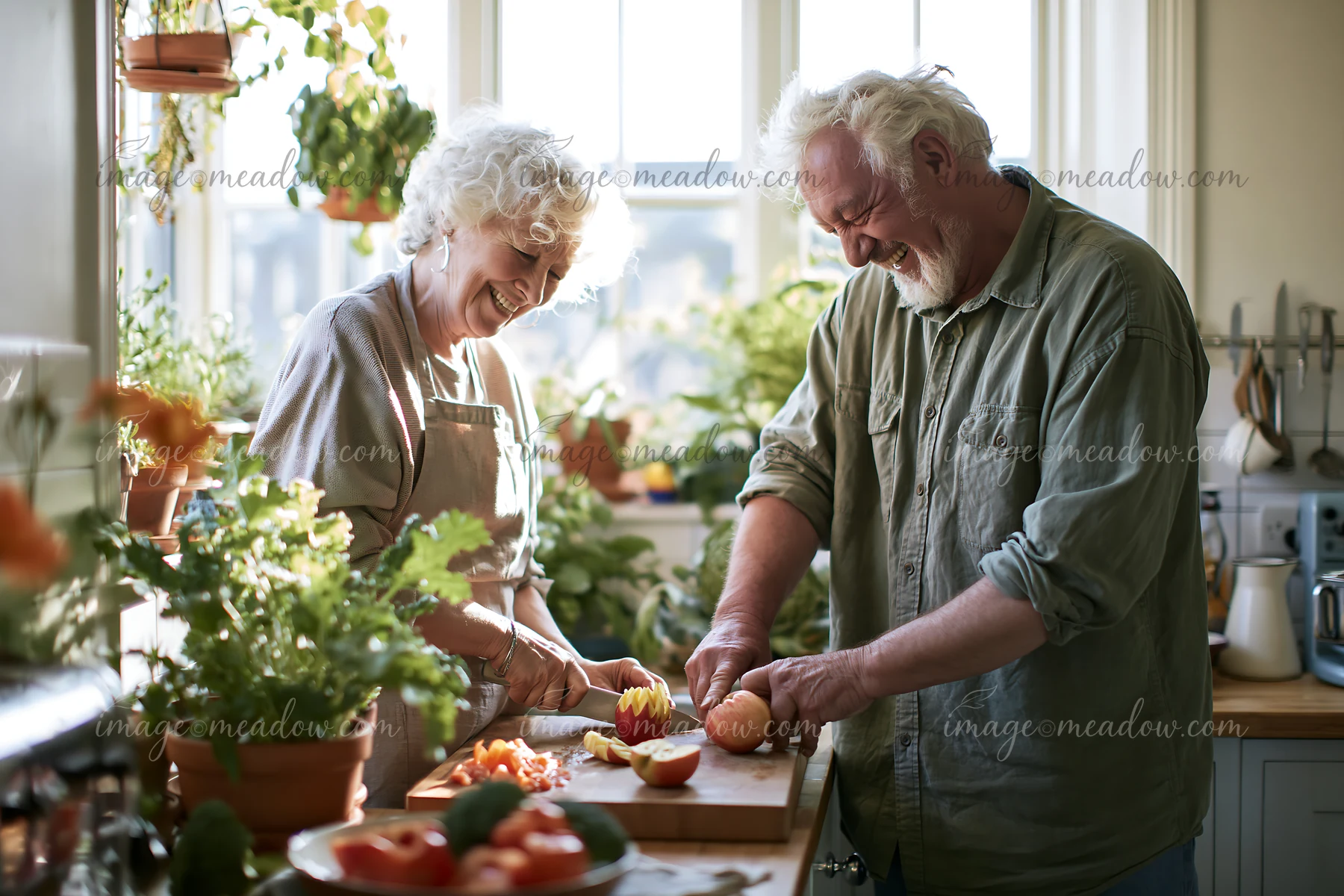 An elderly couple enjoys preparing food together in a bright kitchen filled with plants.