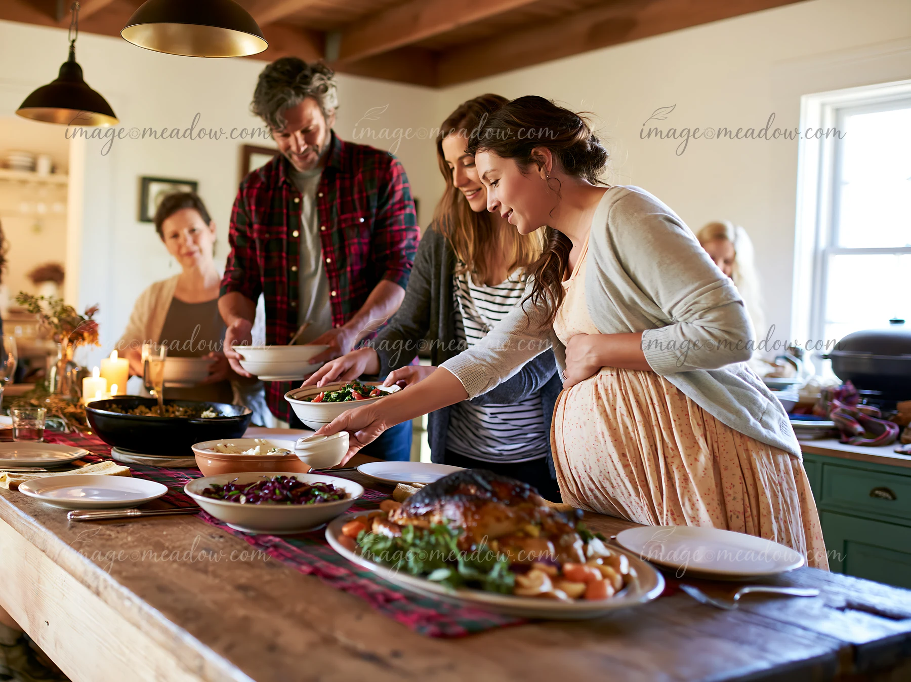 Five adults serve shared holiday dishes around a warmly lit dining table.