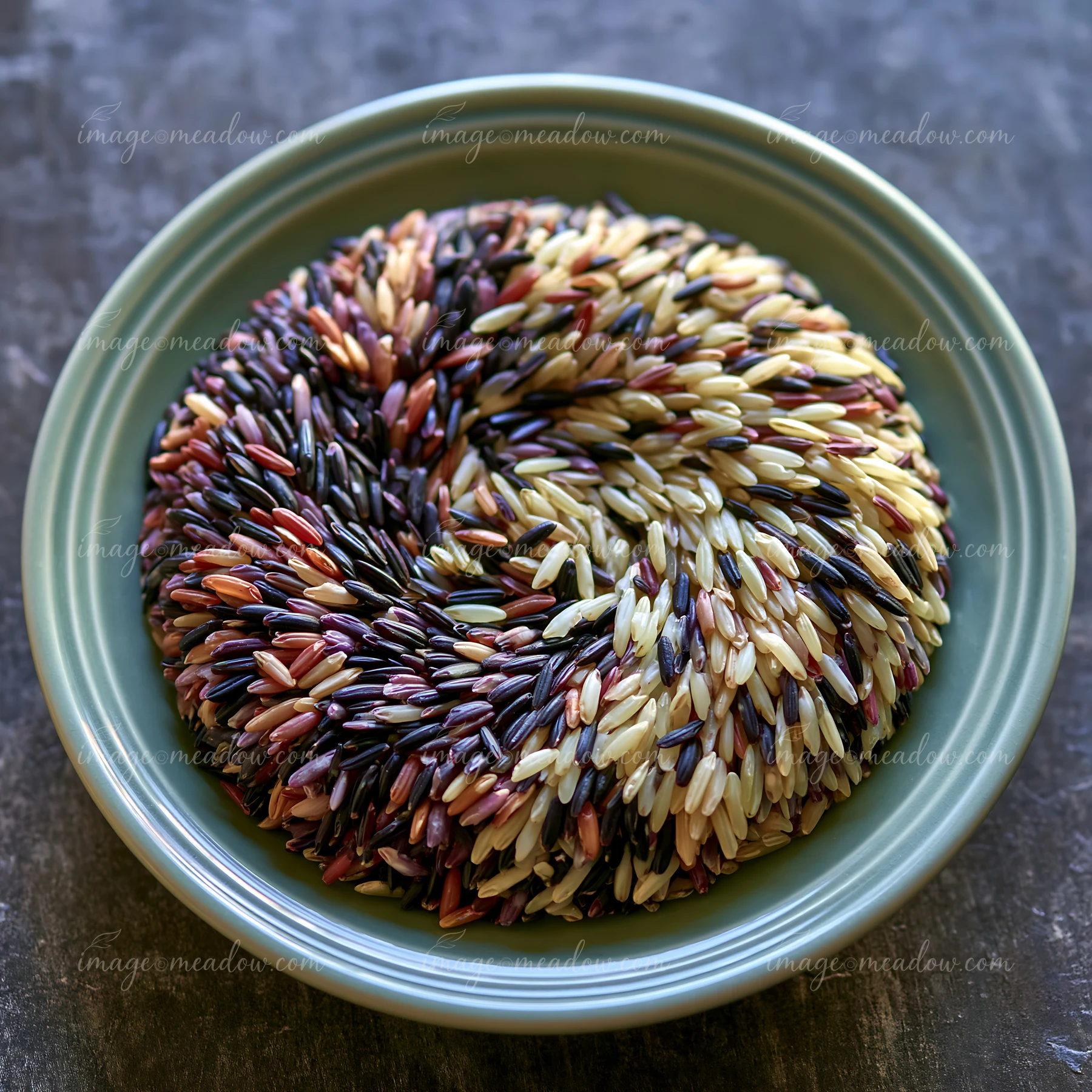 Multicolor rice grains forming swirl create an artistic arrangement on a round plate.