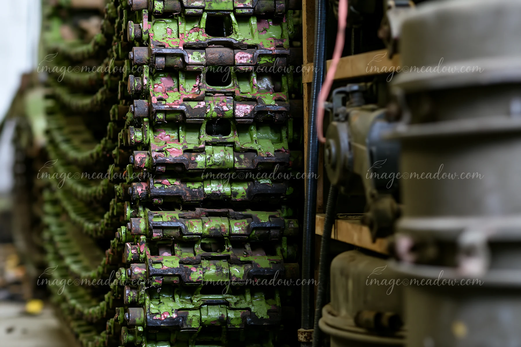 Panzer tank tracks close-up show a detailed view of the metal components stacked in a storage area, with signs of wear and camouflage paint visible on the surfa