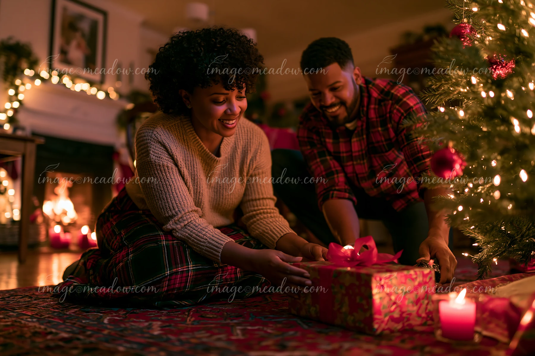 Two parents place wrapped gifts beneath a glowing Christmas tree in a warmly lit living room.