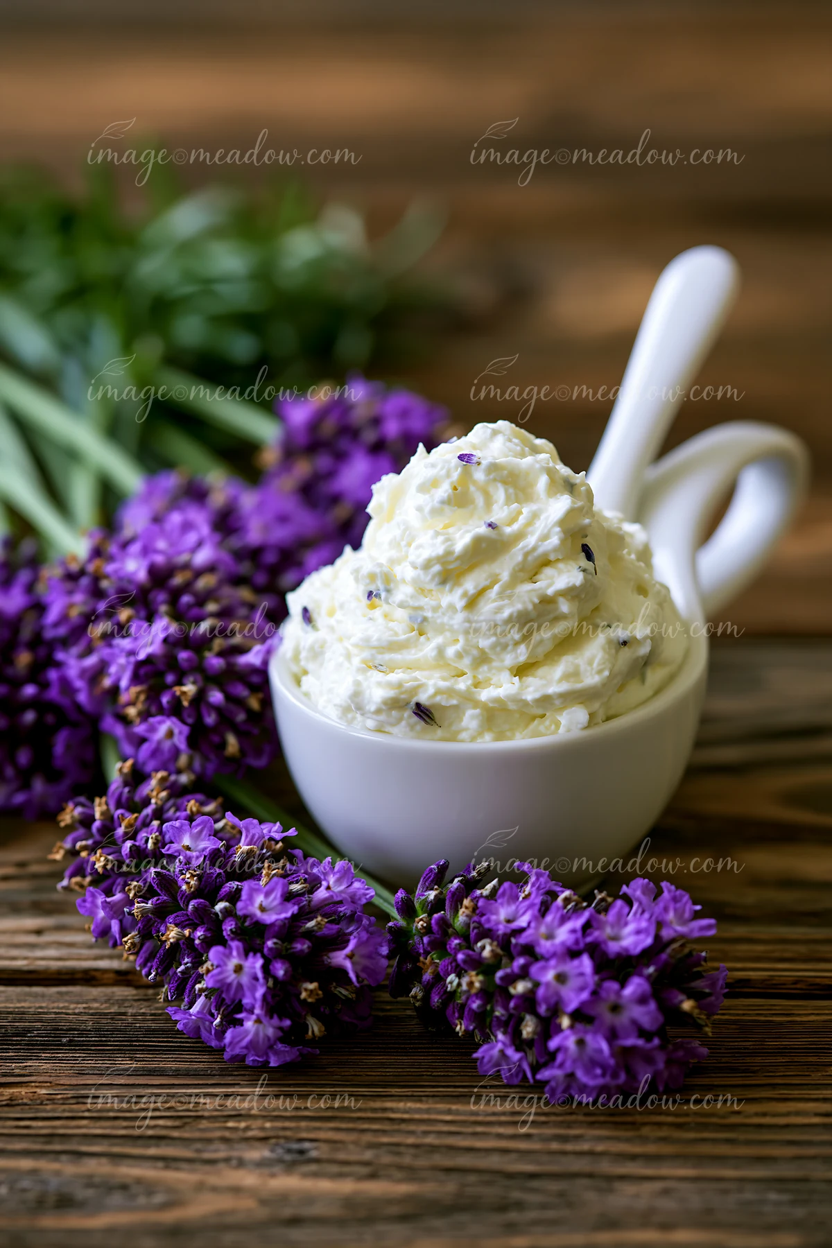 A bowl filled with a cream dose is placed next to fresh lavender flowers on a wooden surface.