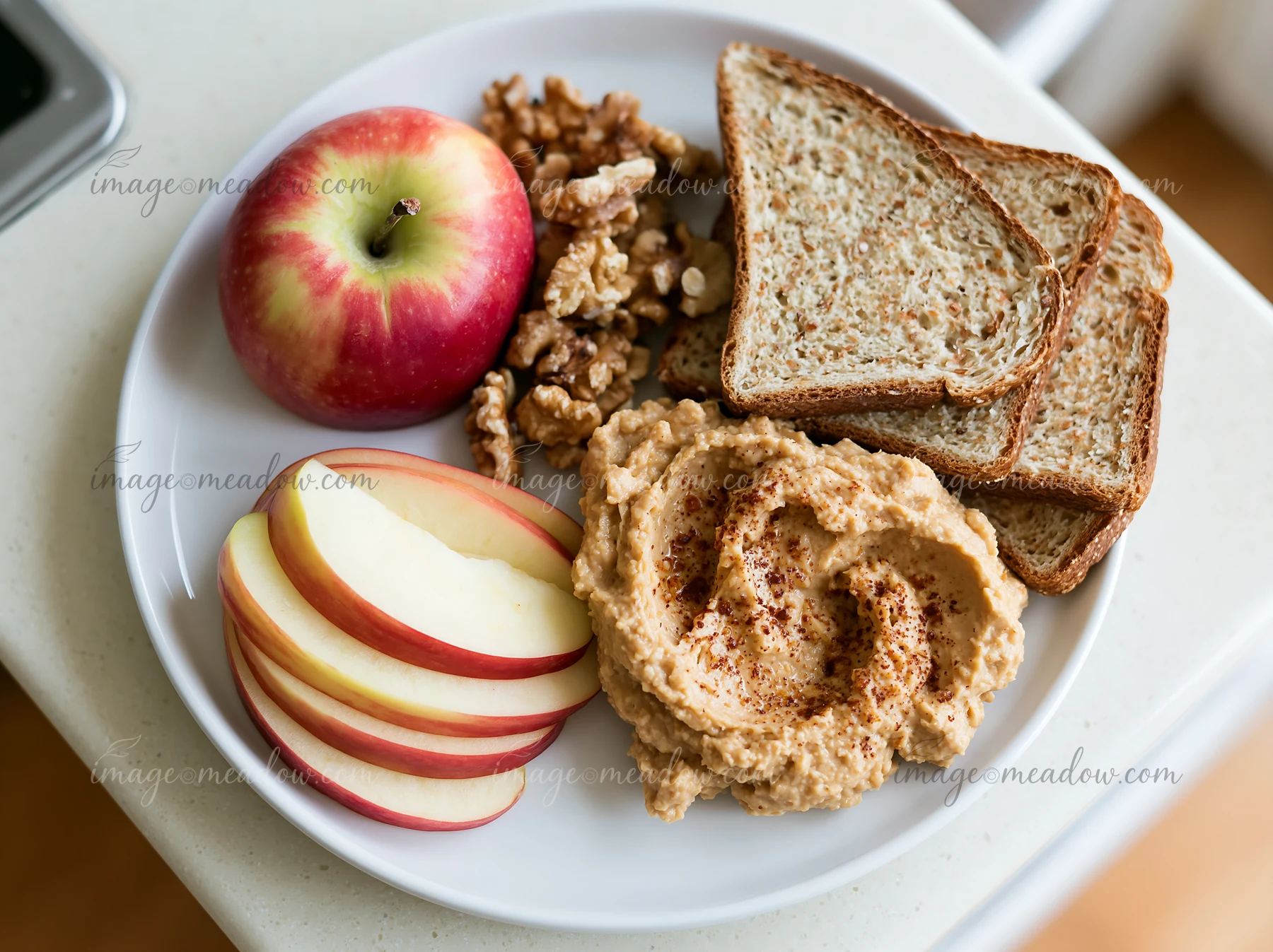 A breakfast plate with hummus is presented on a white dish.