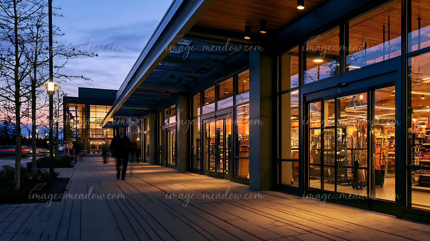 A busy retail store shows its bright interior as people walk by in the evening.