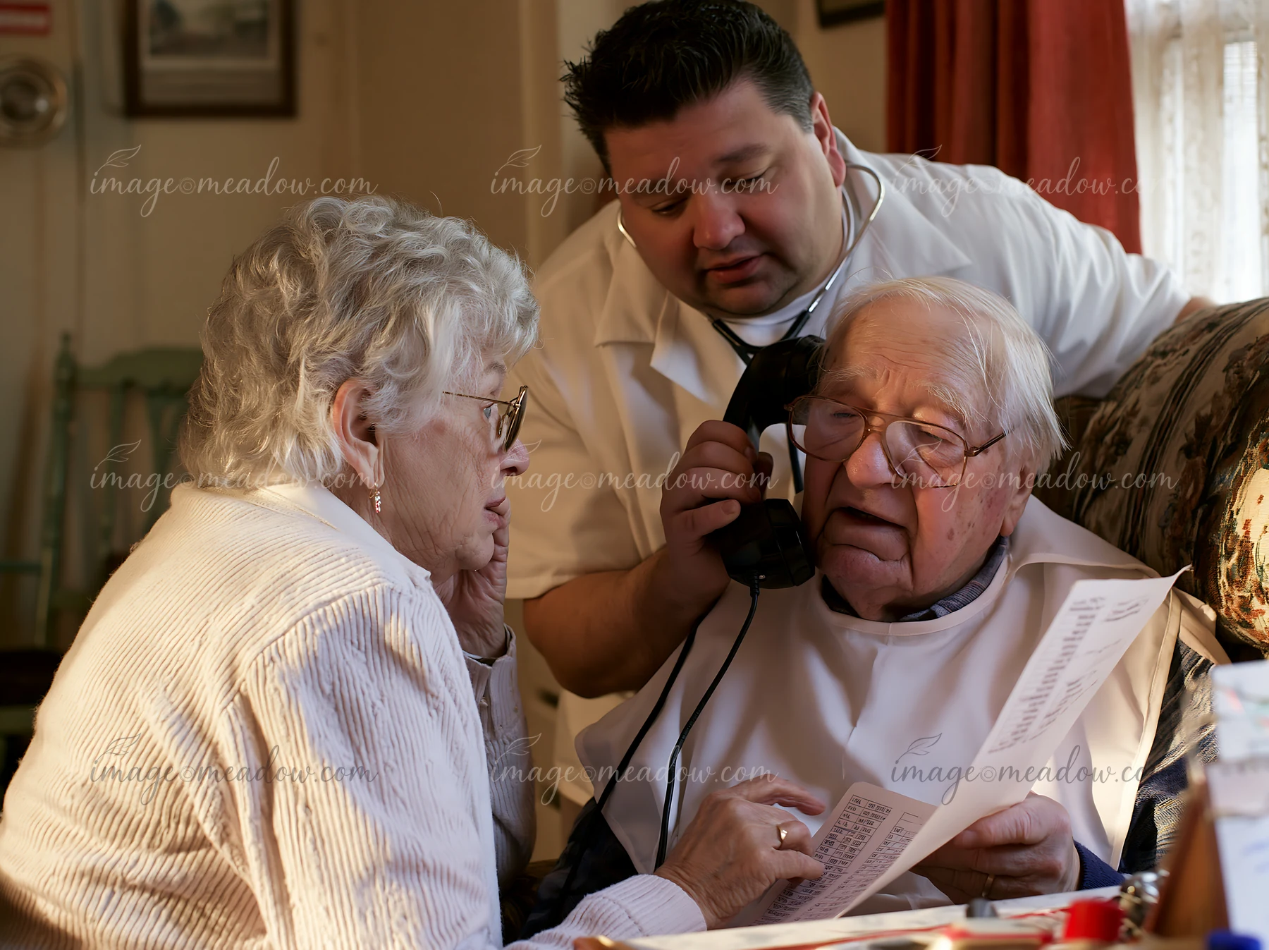 A caregiver helping a confused senior make a phone call in a warm living room.