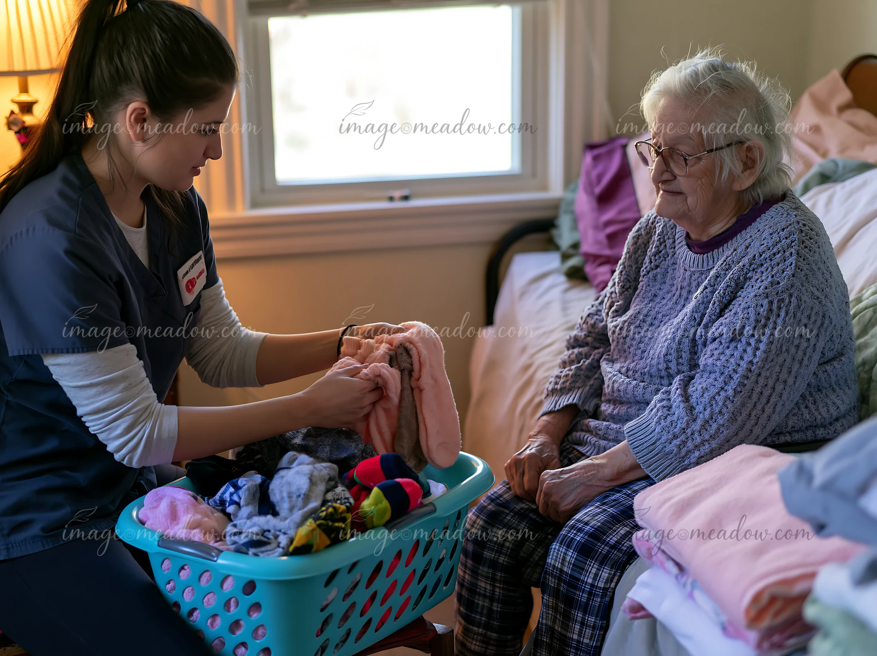 A caregiver is folding laundry while explaining a daily routine to a dementia patient in a cozy bedroom.