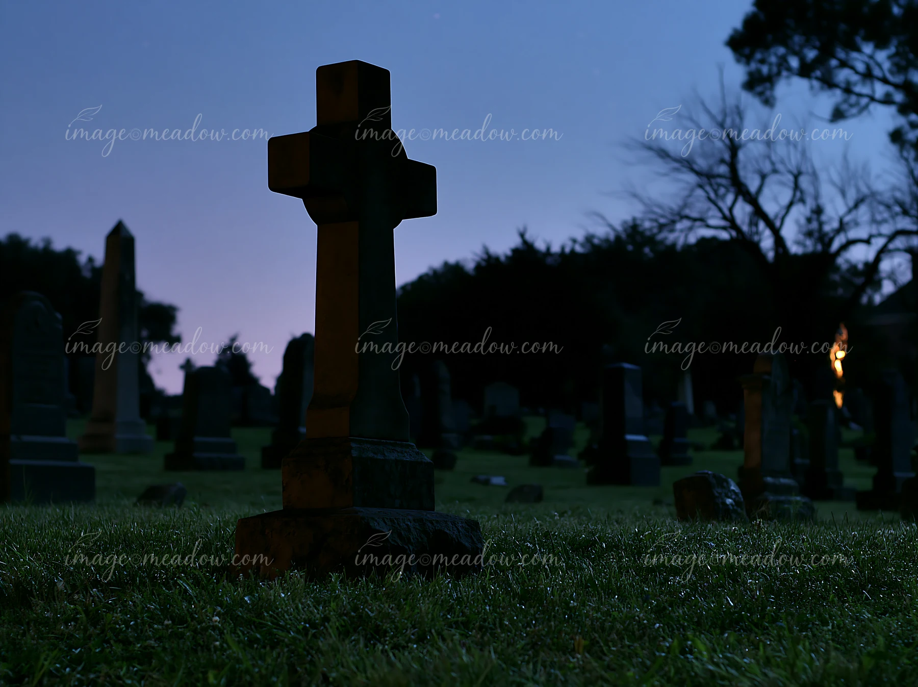 A cemetery dedicated to soldiers features dark gravestones and a cross in the foreground with a night sky filled with stars.