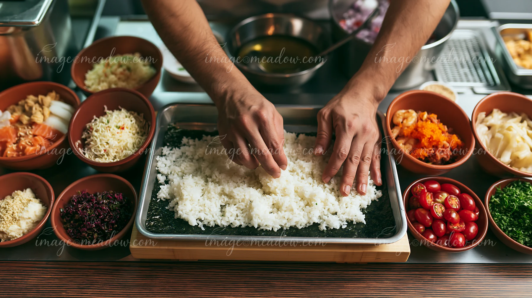 A chef prepares sushi at restaurant counter surrounded by fresh ingredients.