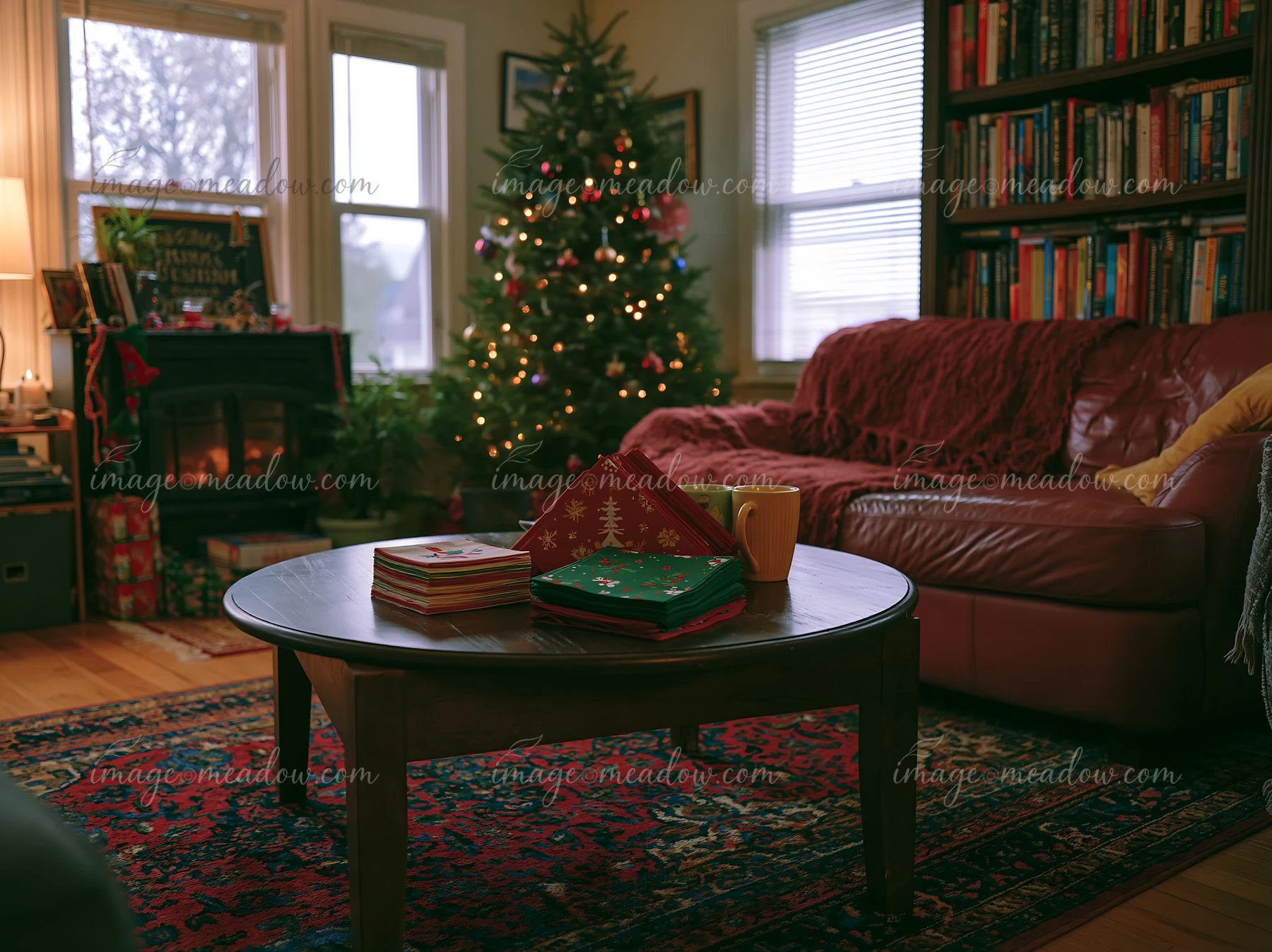 A Christmas living room features a coffee table with colorful coasters and a warm drink.