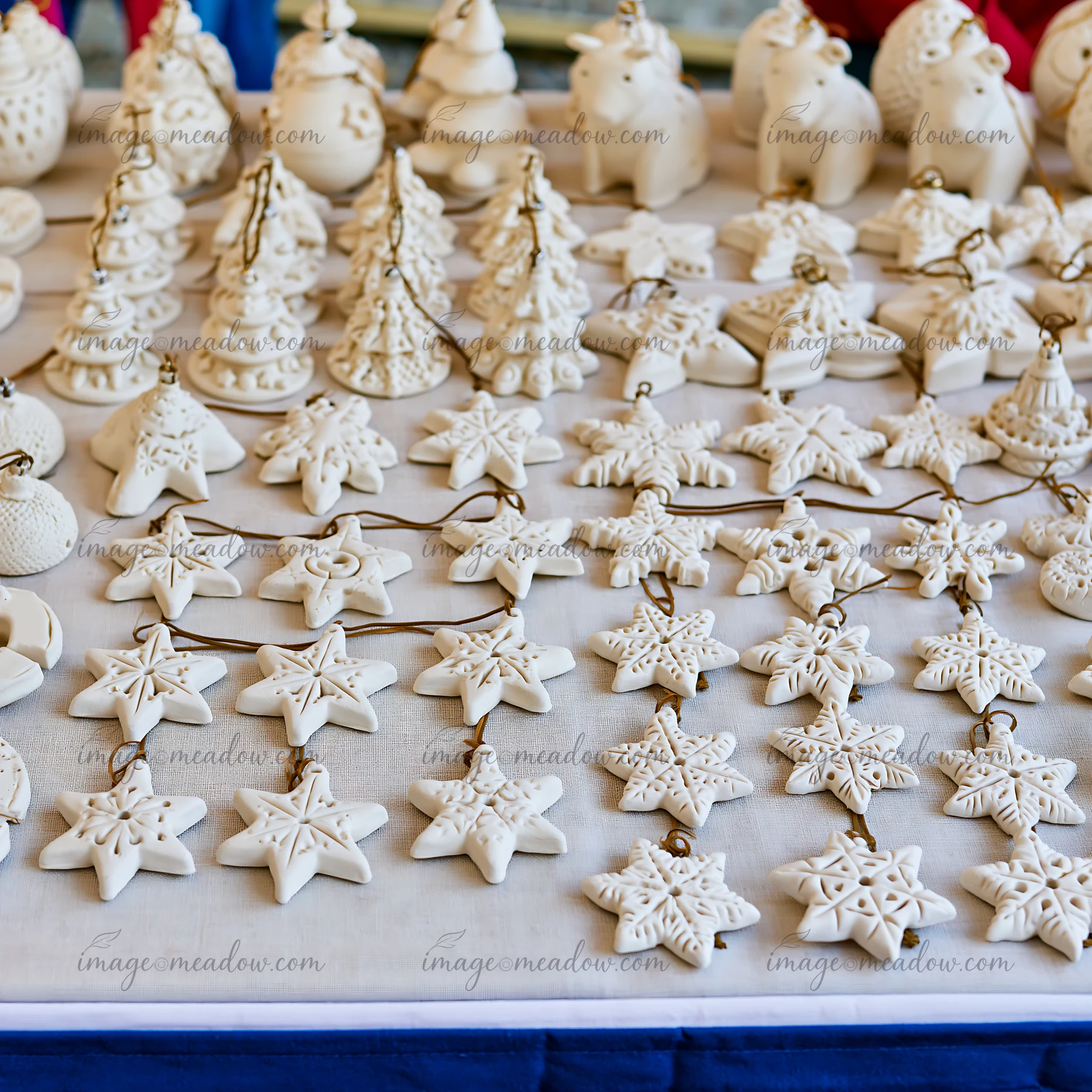 A Christmas market stall showcases various handmade ornaments arranged neatly.