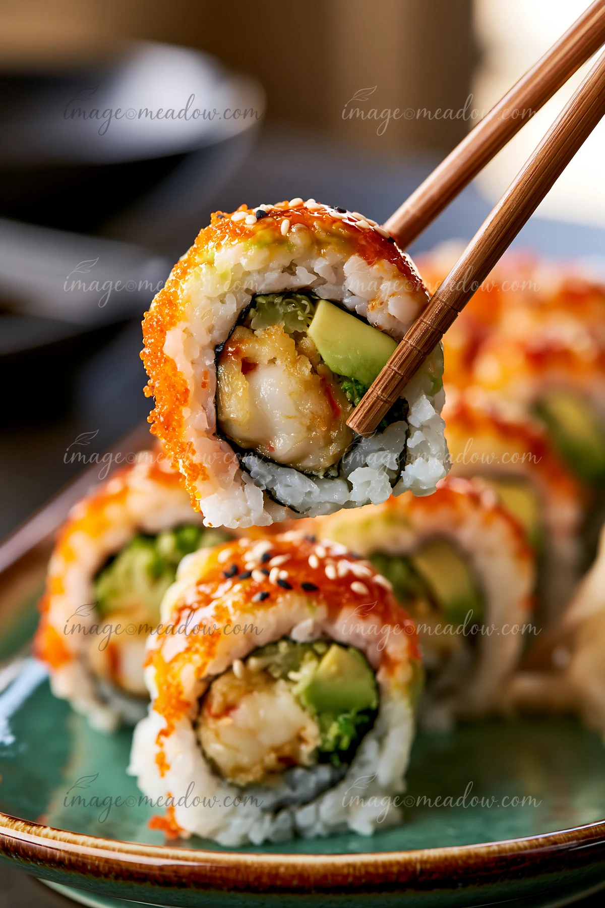 A close-up view of a dragon roll held with chopsticks.