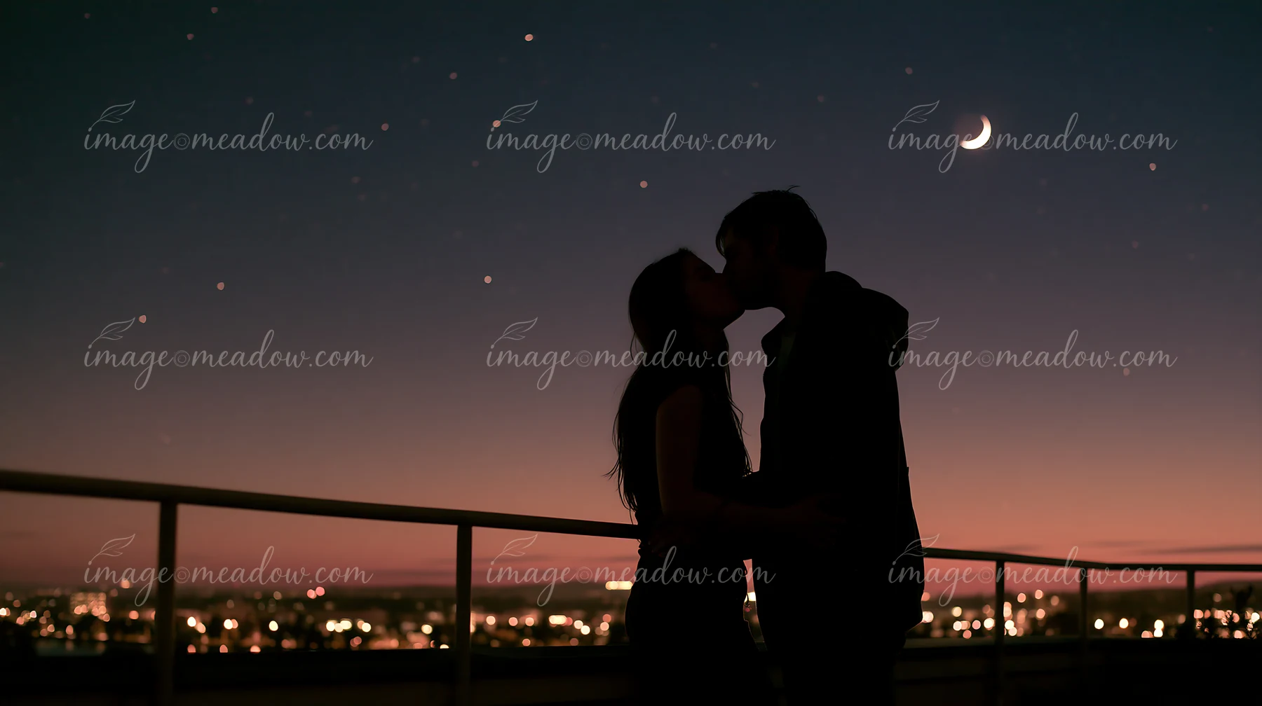 A couple shares a kiss against a backdrop of a twilight sky filled with stars and a crescent moon.