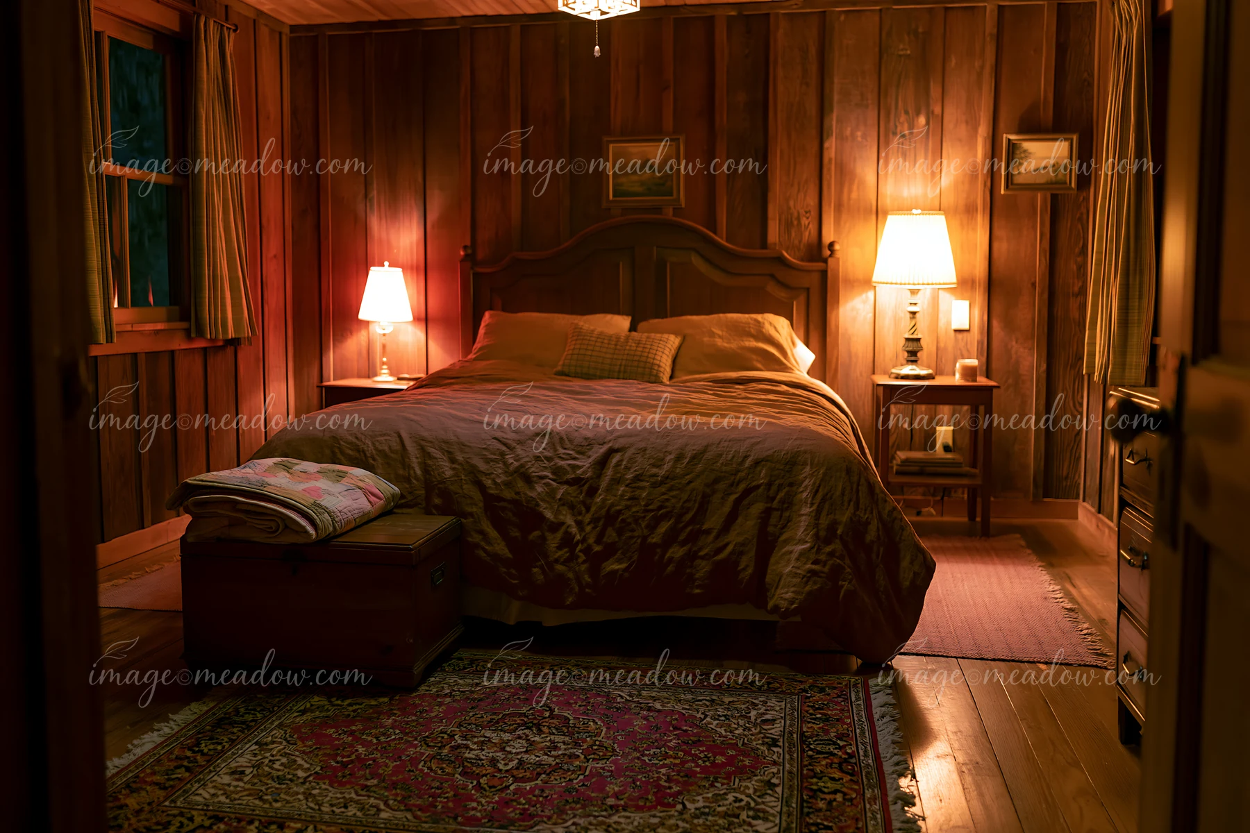 A cozy rustic bedroom features a large bed with linen bedding against wooden walls.