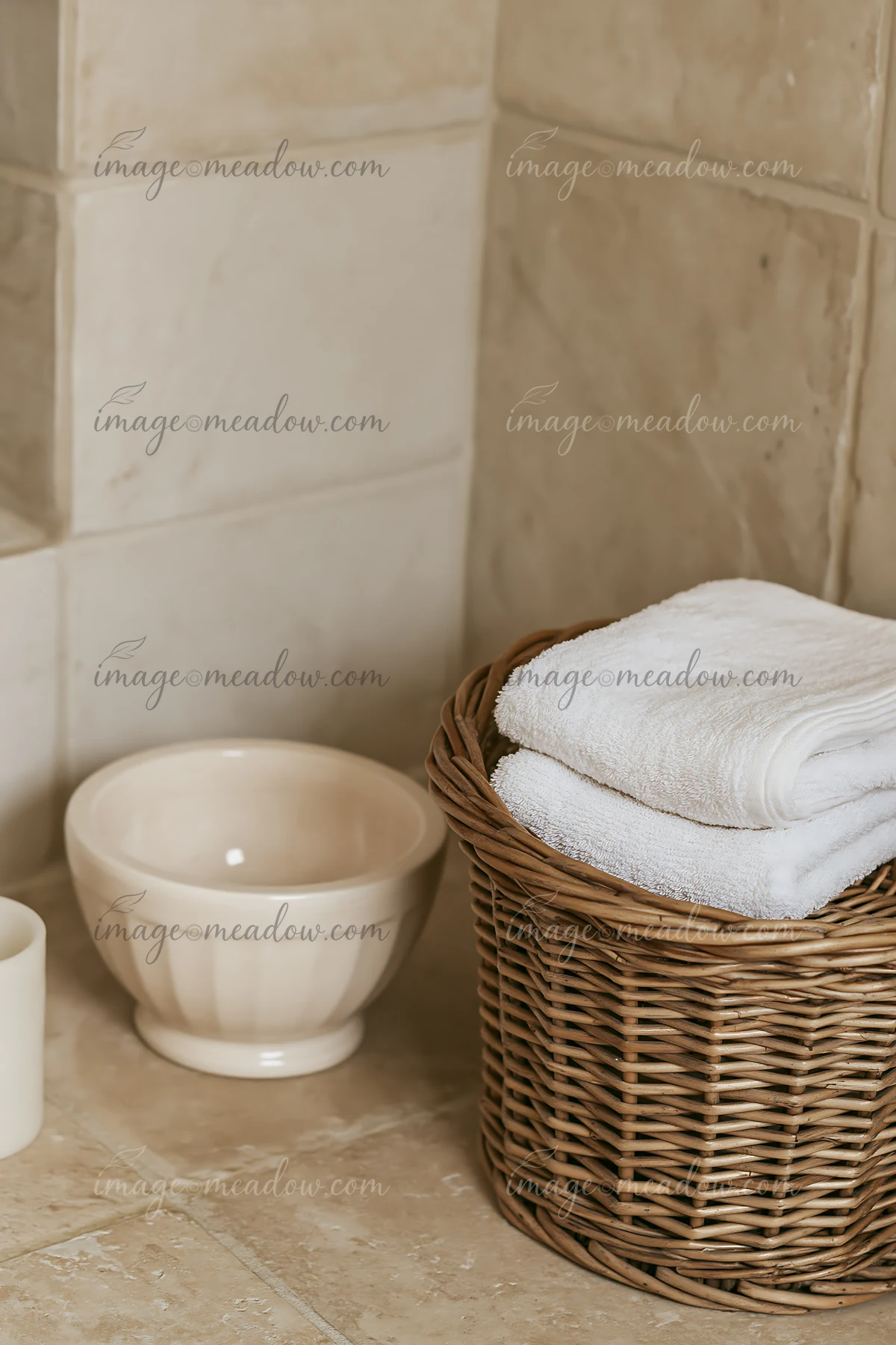 A cream dose is placed beside a folded white towel in a bathroom.