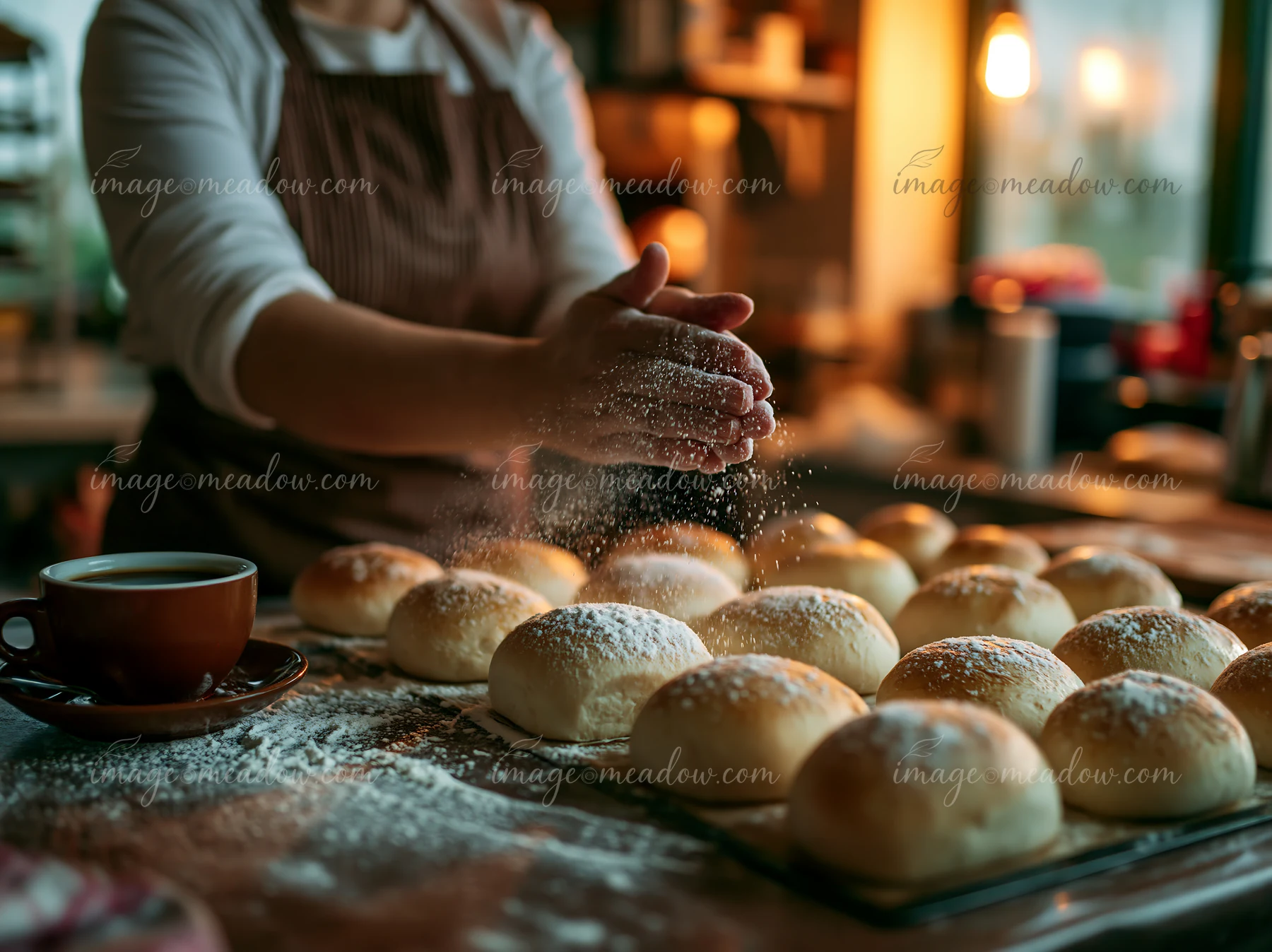 A cup of coffee sits beside a tray of freshly baked bread.