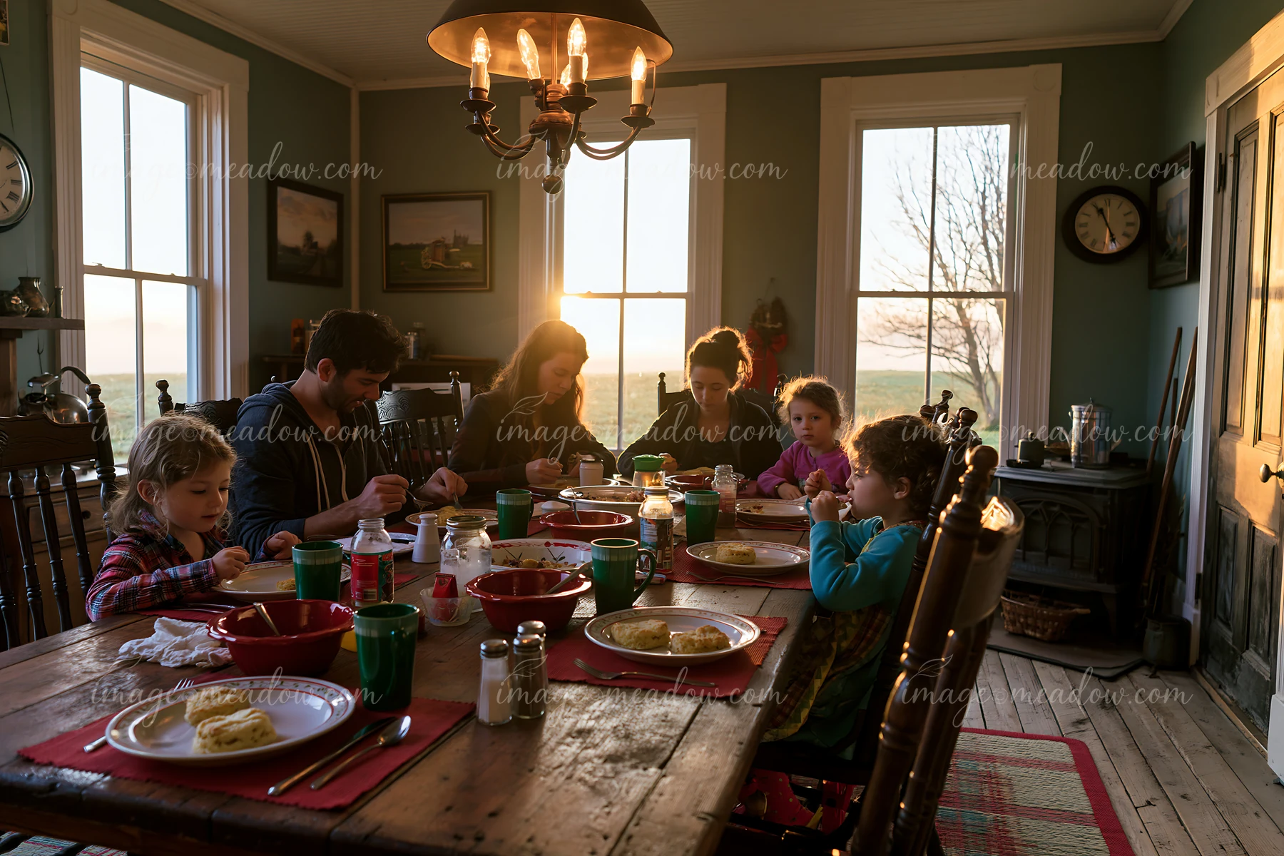 A family gathers around a table for breakfast in a cozy dining room, enjoying their meal while sunlight streams through the windows.