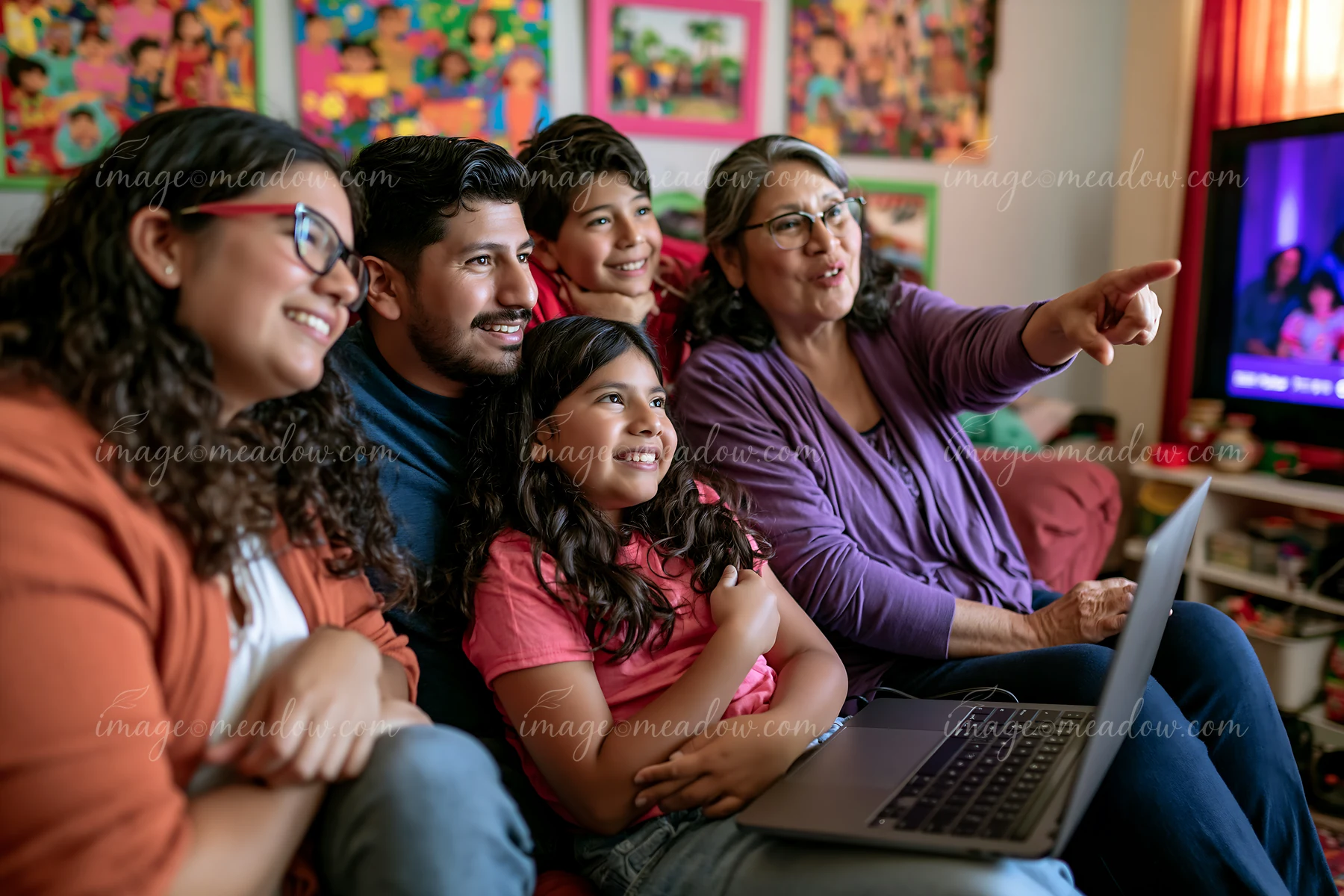 A family gathers on a couch at home to watch a holiday movie.
