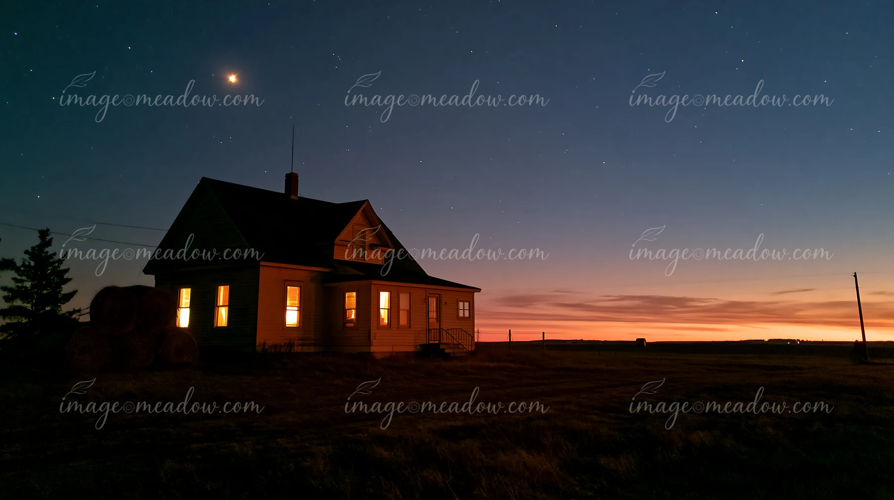 A farmhouse stands alone beneath the night sky as stars twinkle above.