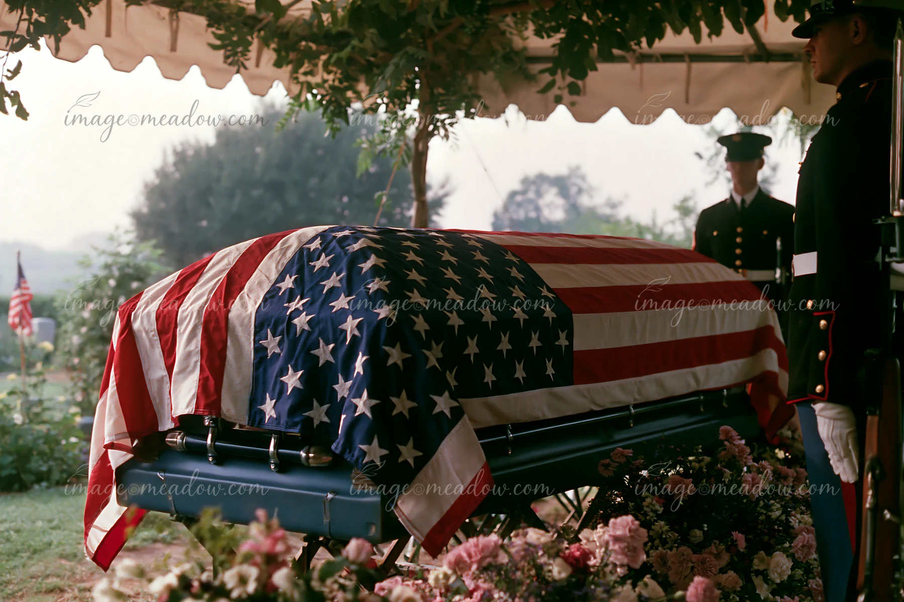 A flag-draped coffin is present during a veteran funeral service in a cemetery.