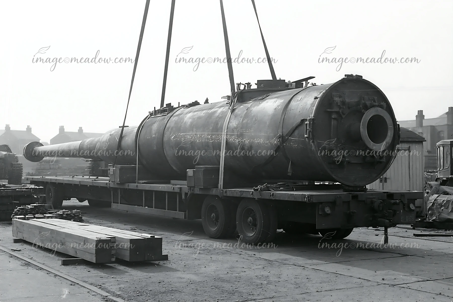 A large panzer tank gun barrel rests on a transport vehicle, showing the mechanical details and construction.