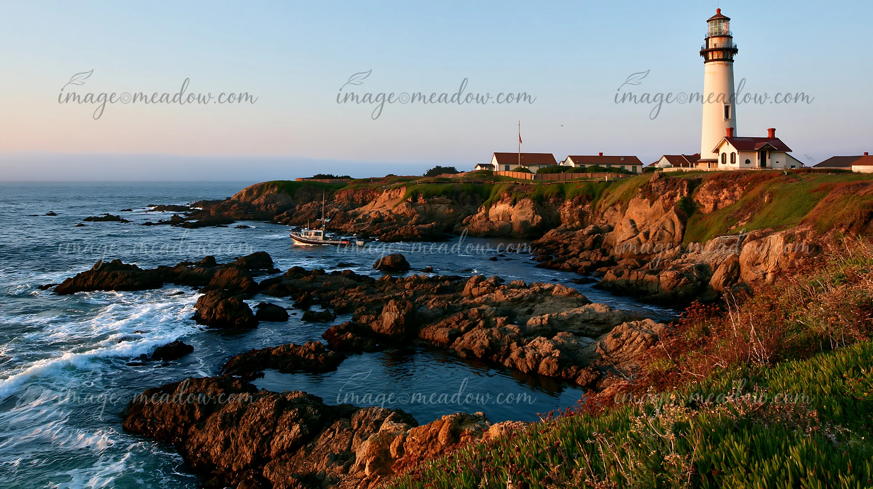 A lighthouse stands tall next to a rocky tide pool with waves crashing against the rocks.