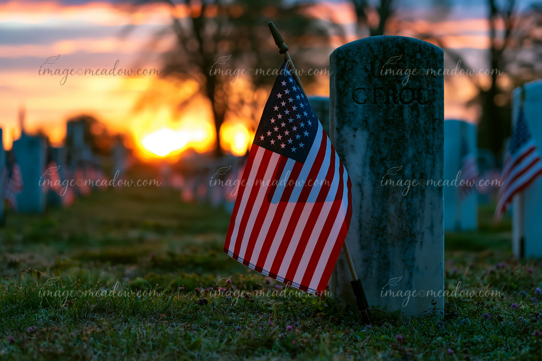 A military cemetery is bathed in soft light from the sunrise after a starry night.