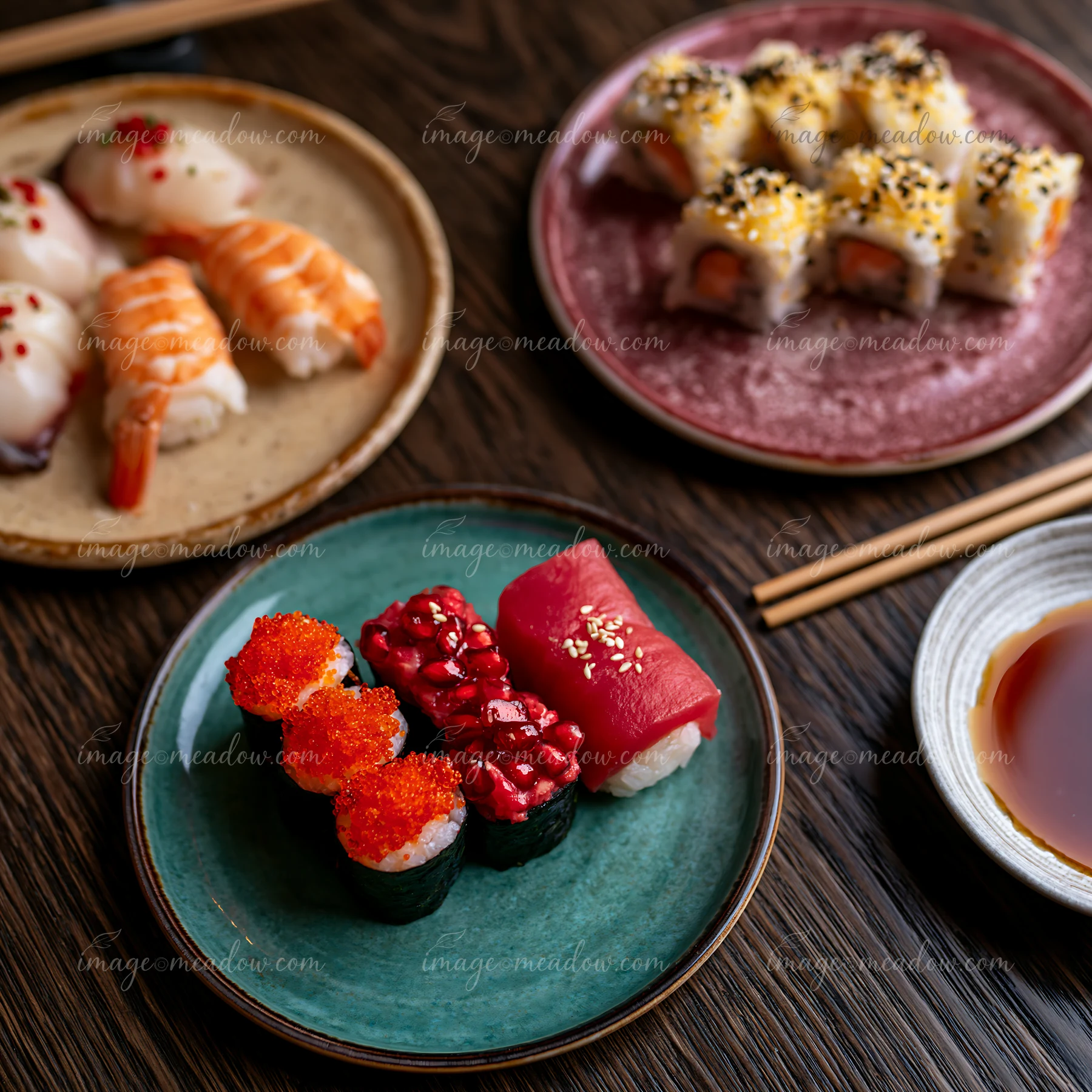 A modern sushi presentation close-up shows various sushi types arranged on colored plates.