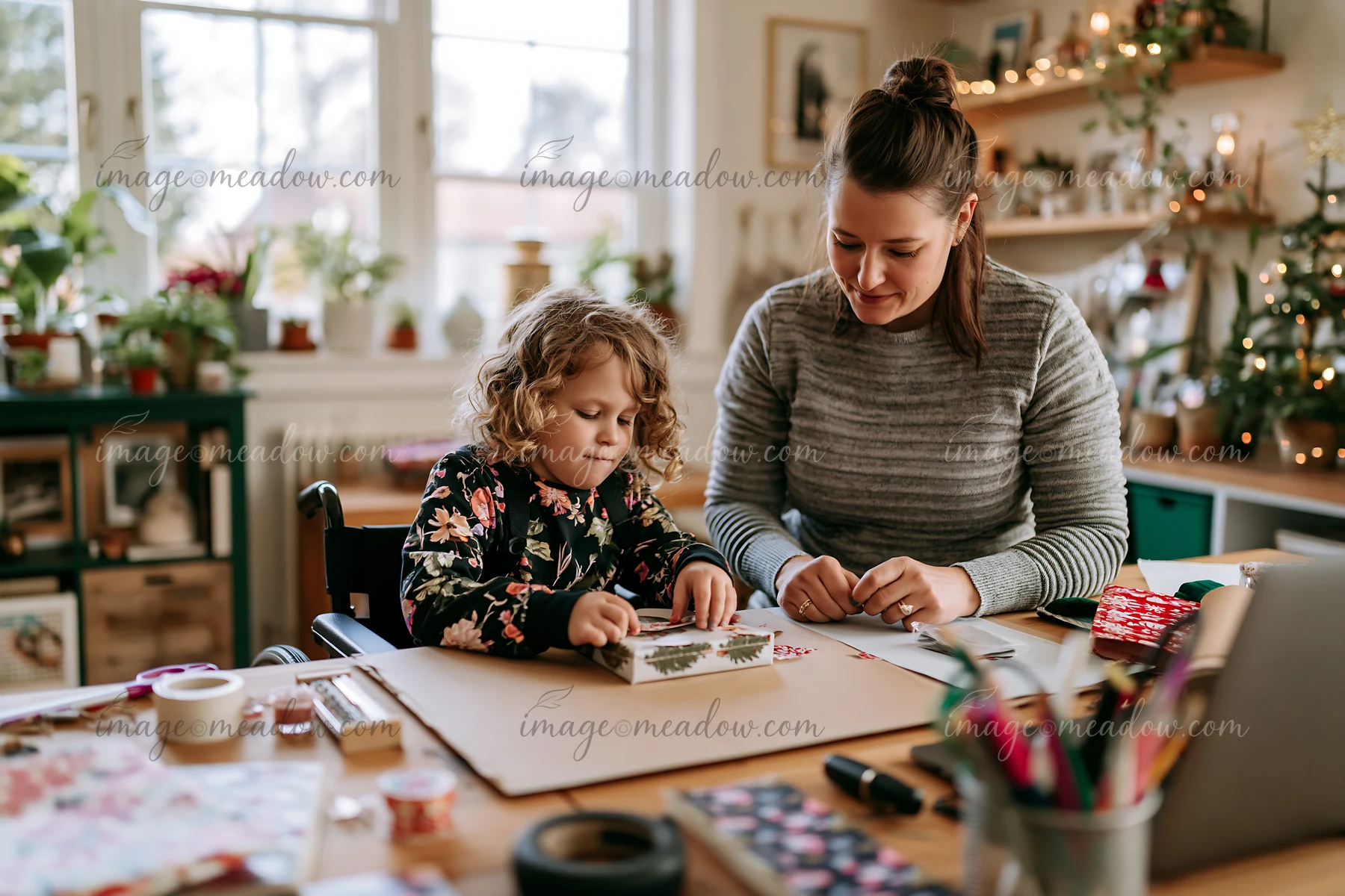 A mother and her daughter are wrapping gifts together in a cozy living room.