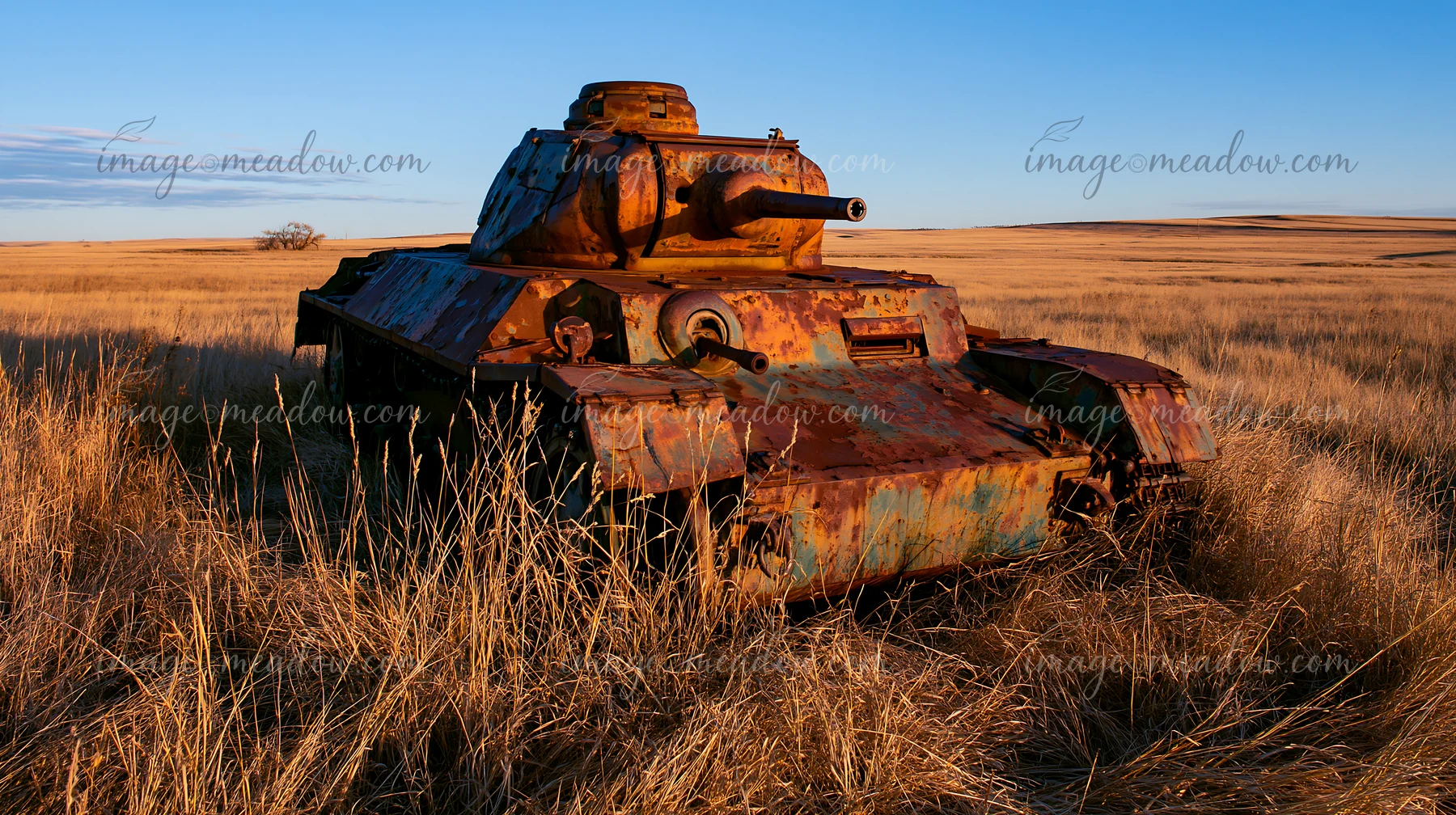 A panzer tank surrounded by grass sits in an open field.