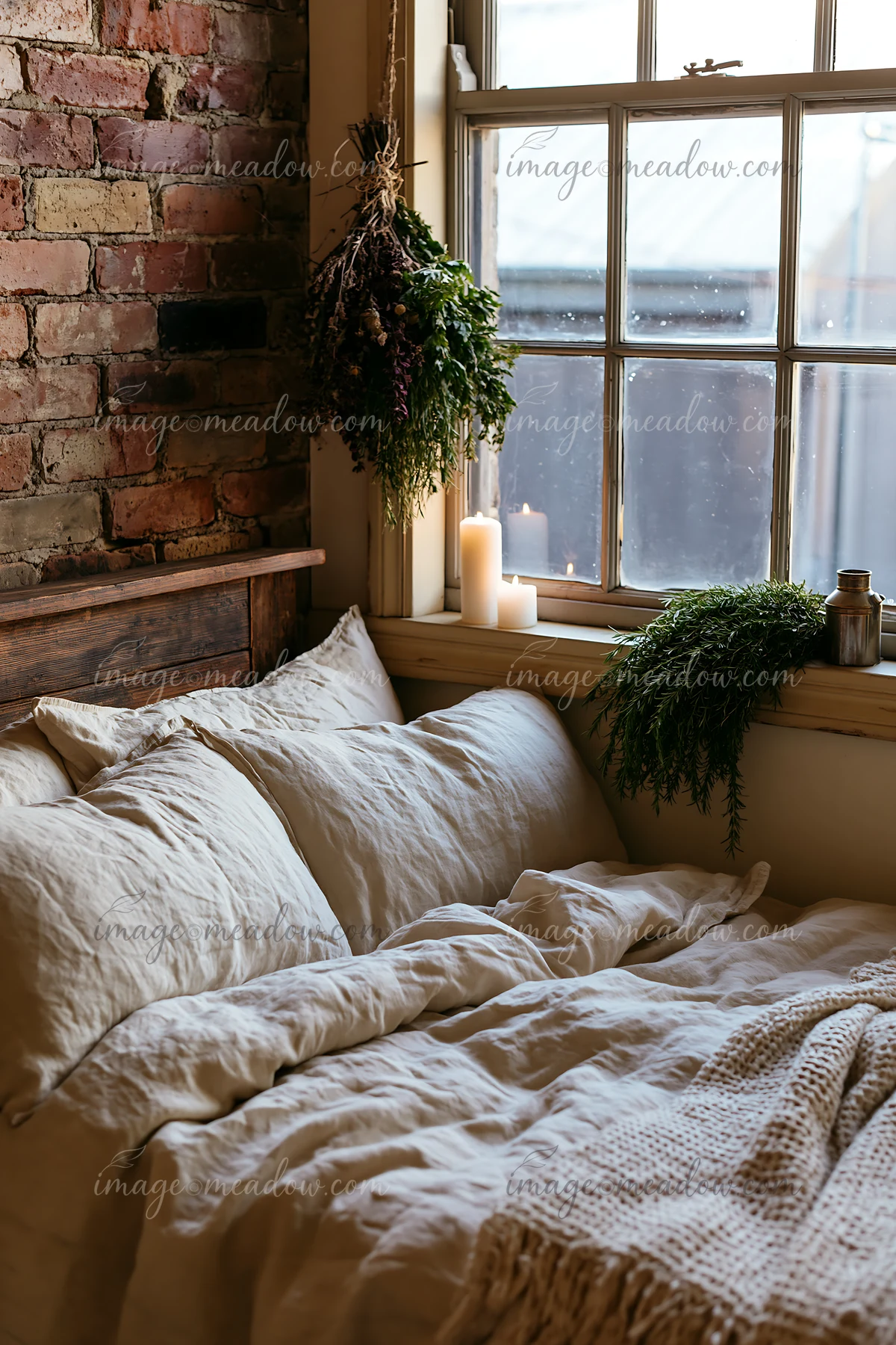 A rustic bedroom features linen bedding layered on a wooden bed frame.