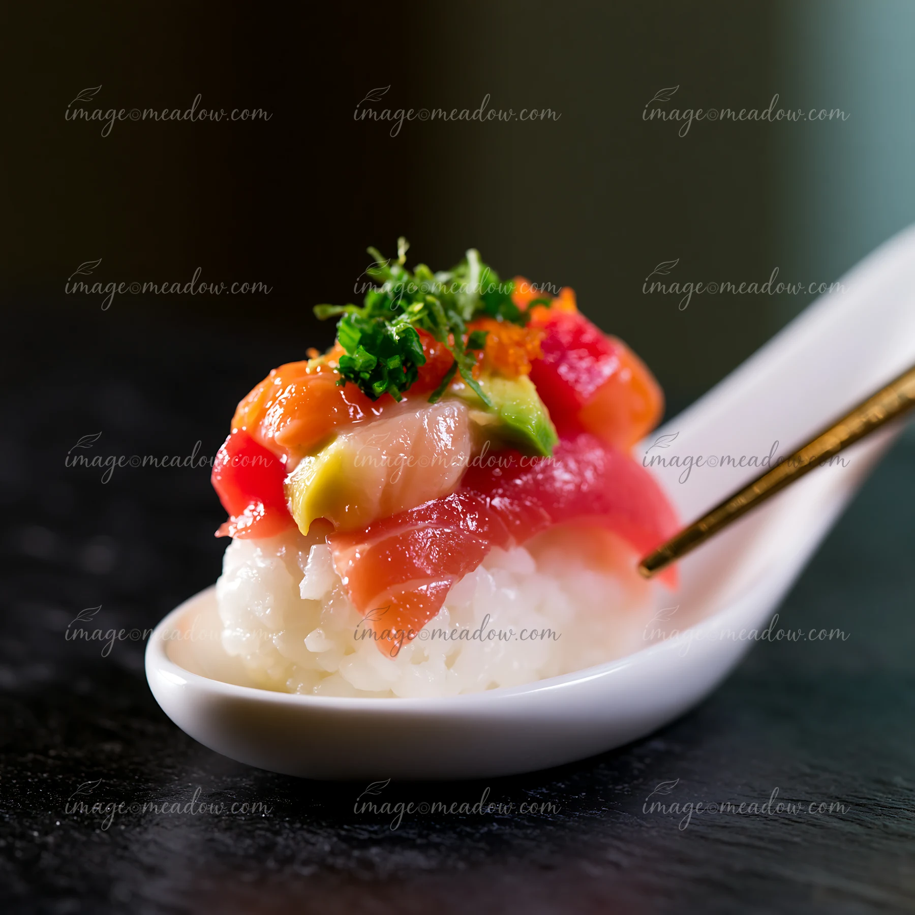 A single sushi piece with colorful fish topping rests on a white spoon.