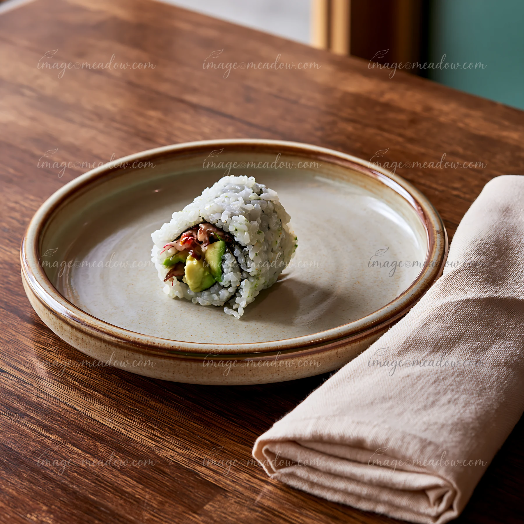 A single sushi roll on ceramic plate resting on a wooden table.