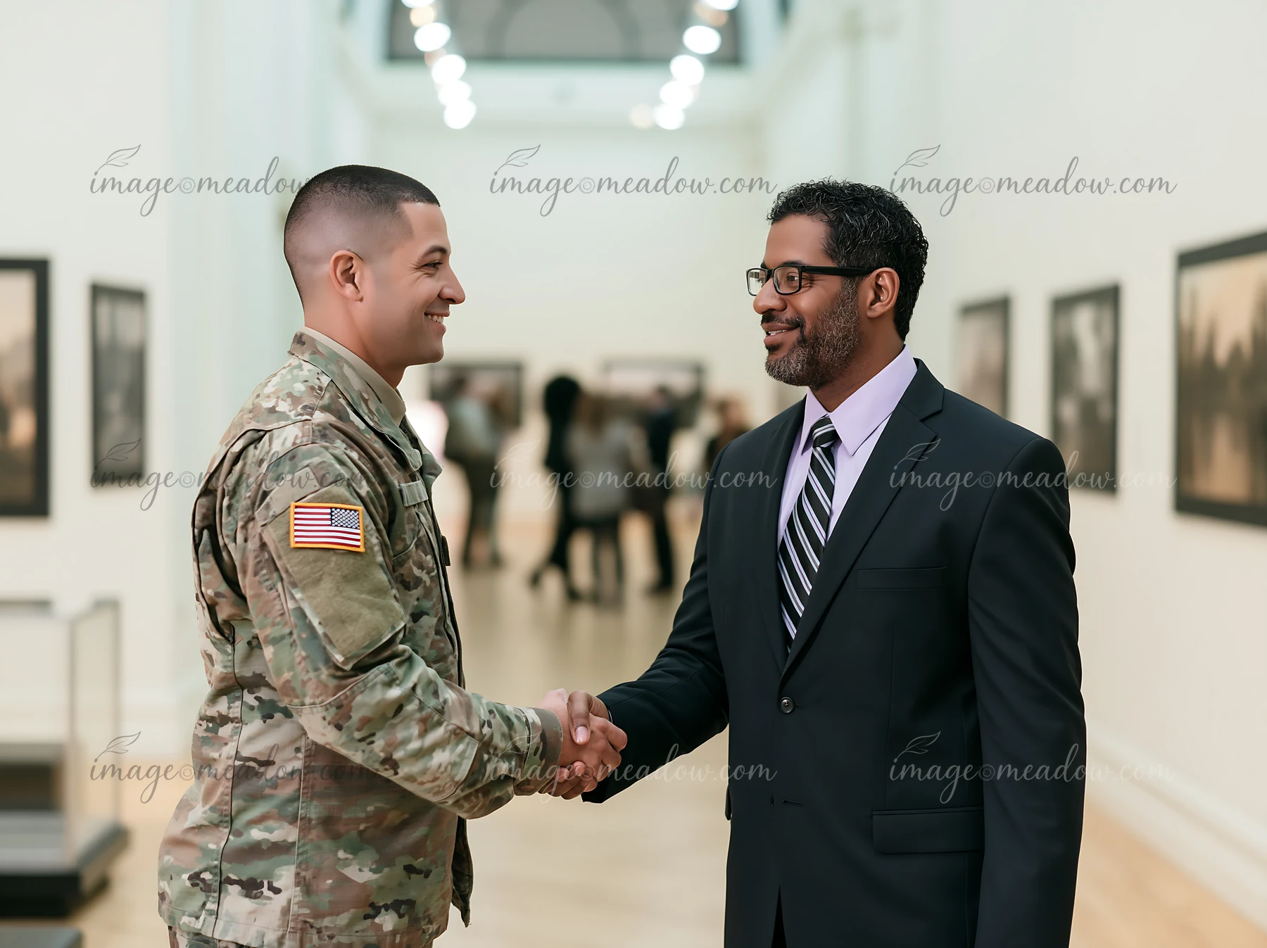 A soldier shaking hands with a man in a suit at an art gallery.