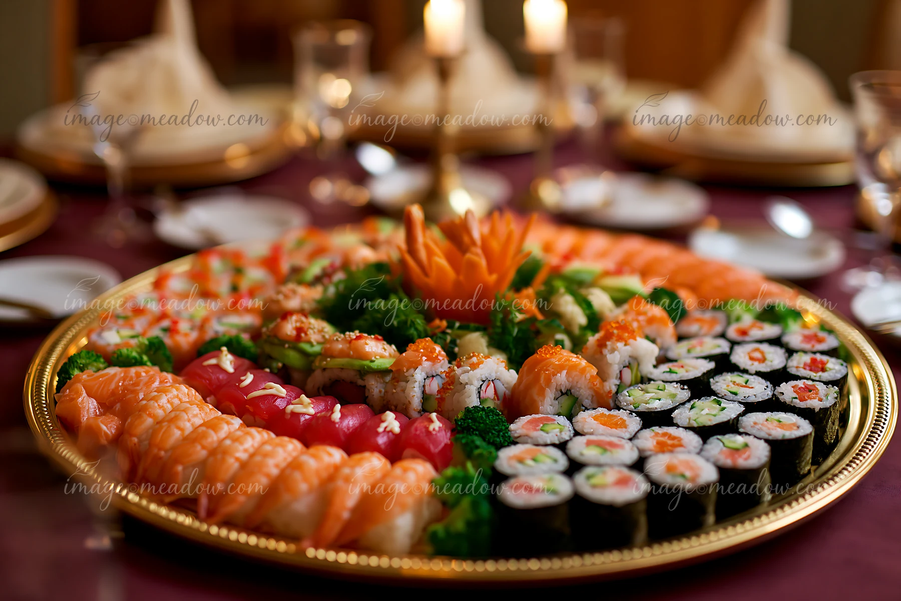 A sushi catering platter sits on a table, featuring a variety of sushi rolls, sashimi, and garnishes.