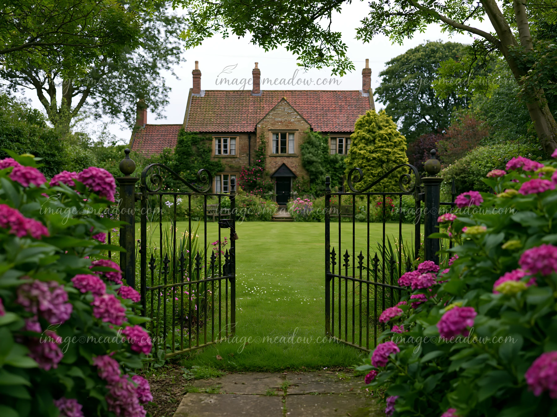 A traditional country house exterior features lush greenery and vibrant flowers.