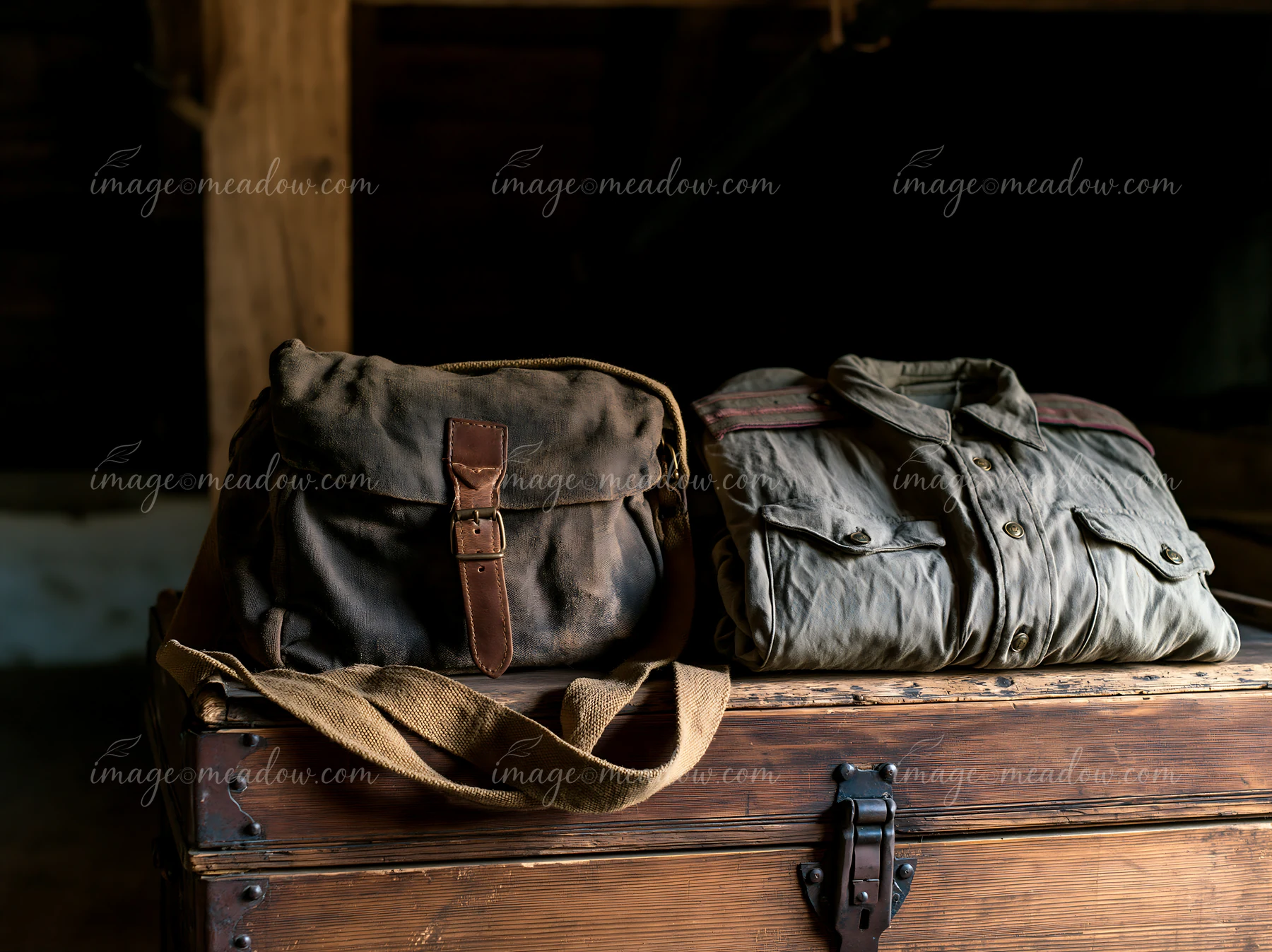 A vintage trunk displays Soviet military uniforms and a bag in a dimly lit room.