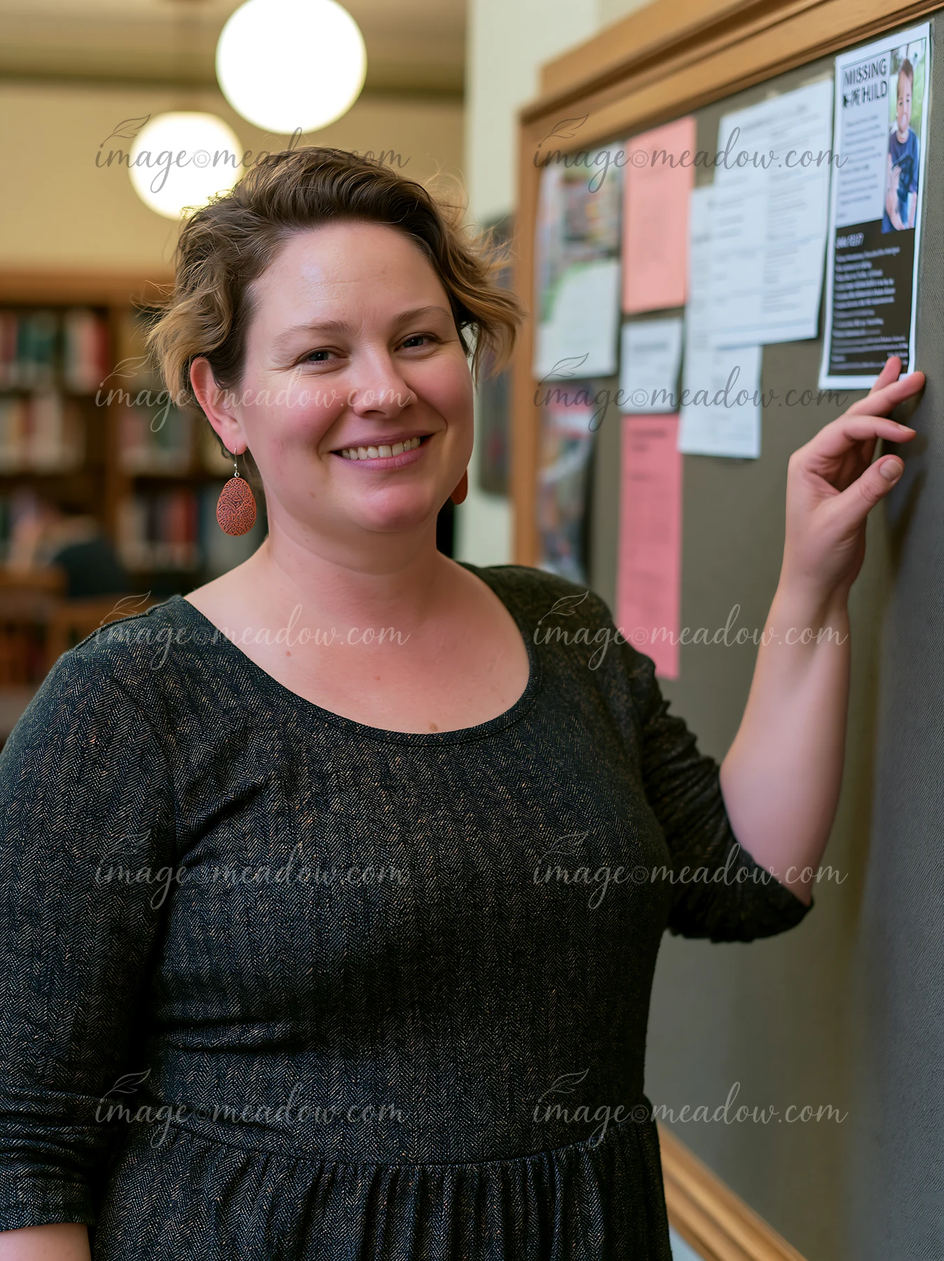 A woman is placing a flyer about a missing child on a bulletin board in a library.