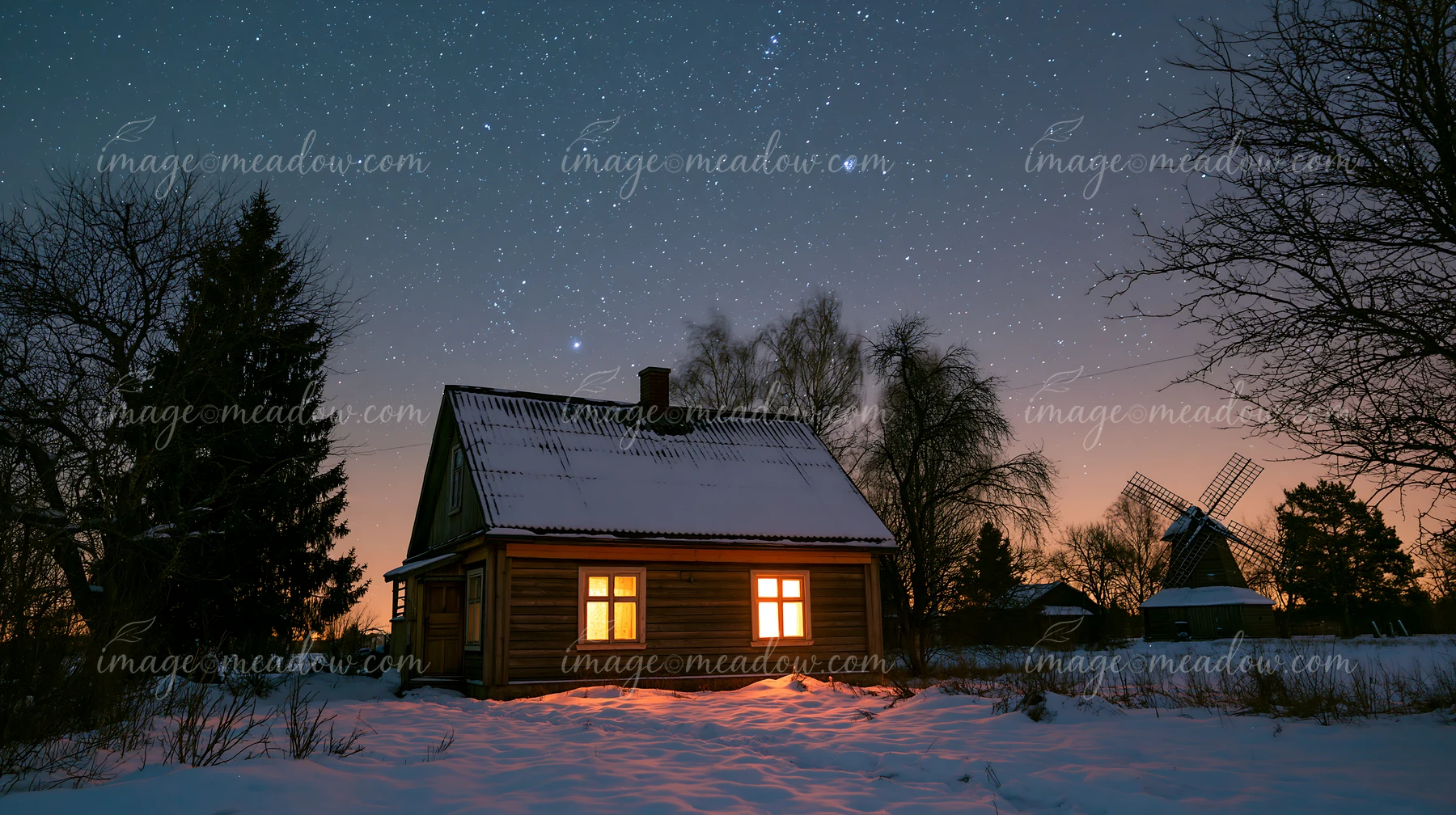 A wooden house sits under a clear night sky filled with stars.